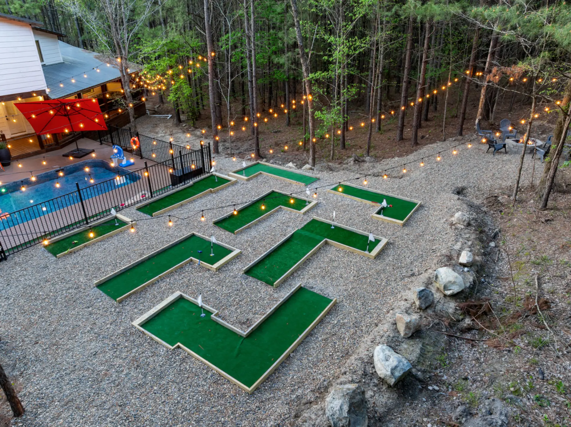 Custom 9-hole mini-putt course exclusively yours — lit with bistro string lights at night, surrounded by Hochatown pine forest. No tee time needed.