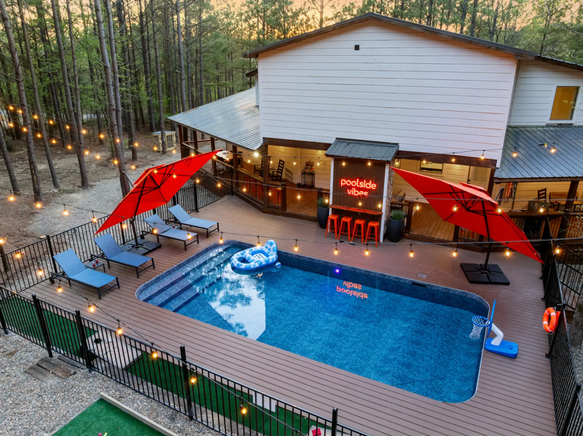 Brand-new private pool deck with custom mini-putt, premium loungers, red umbrellas & outdoor bartop — the ultimate Broken Bow luxury cabin experience for groups up to 14.