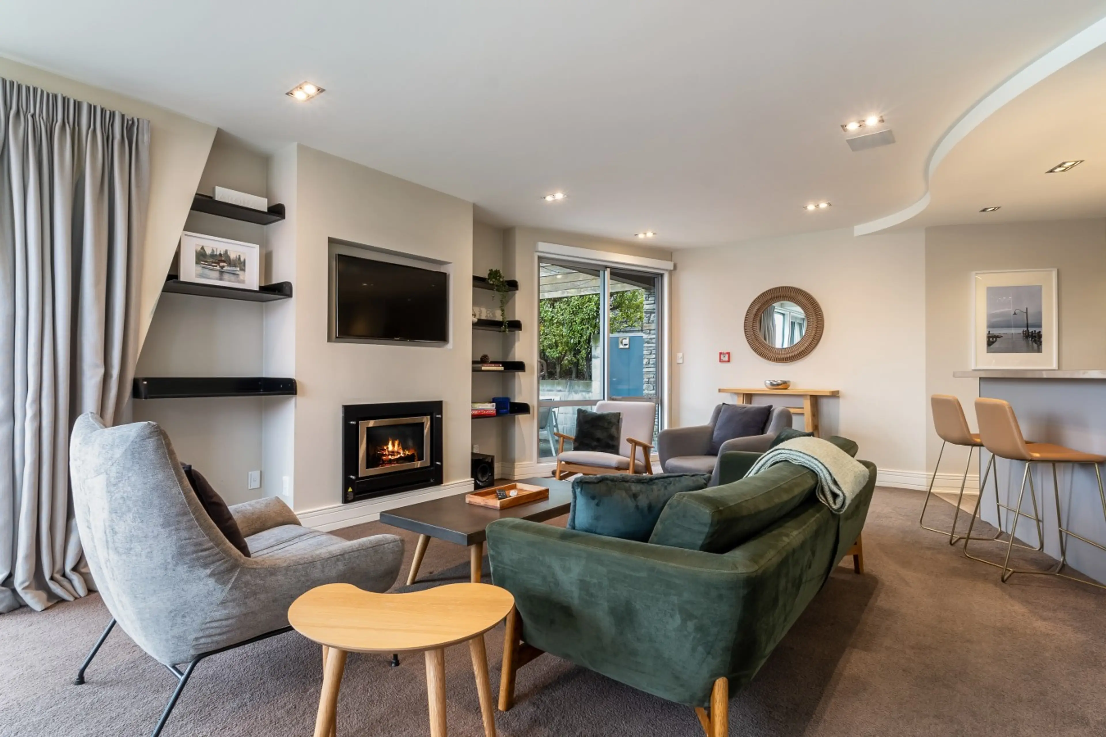Open-plan living with a gas fireplace, comfortable seating, and lake views.