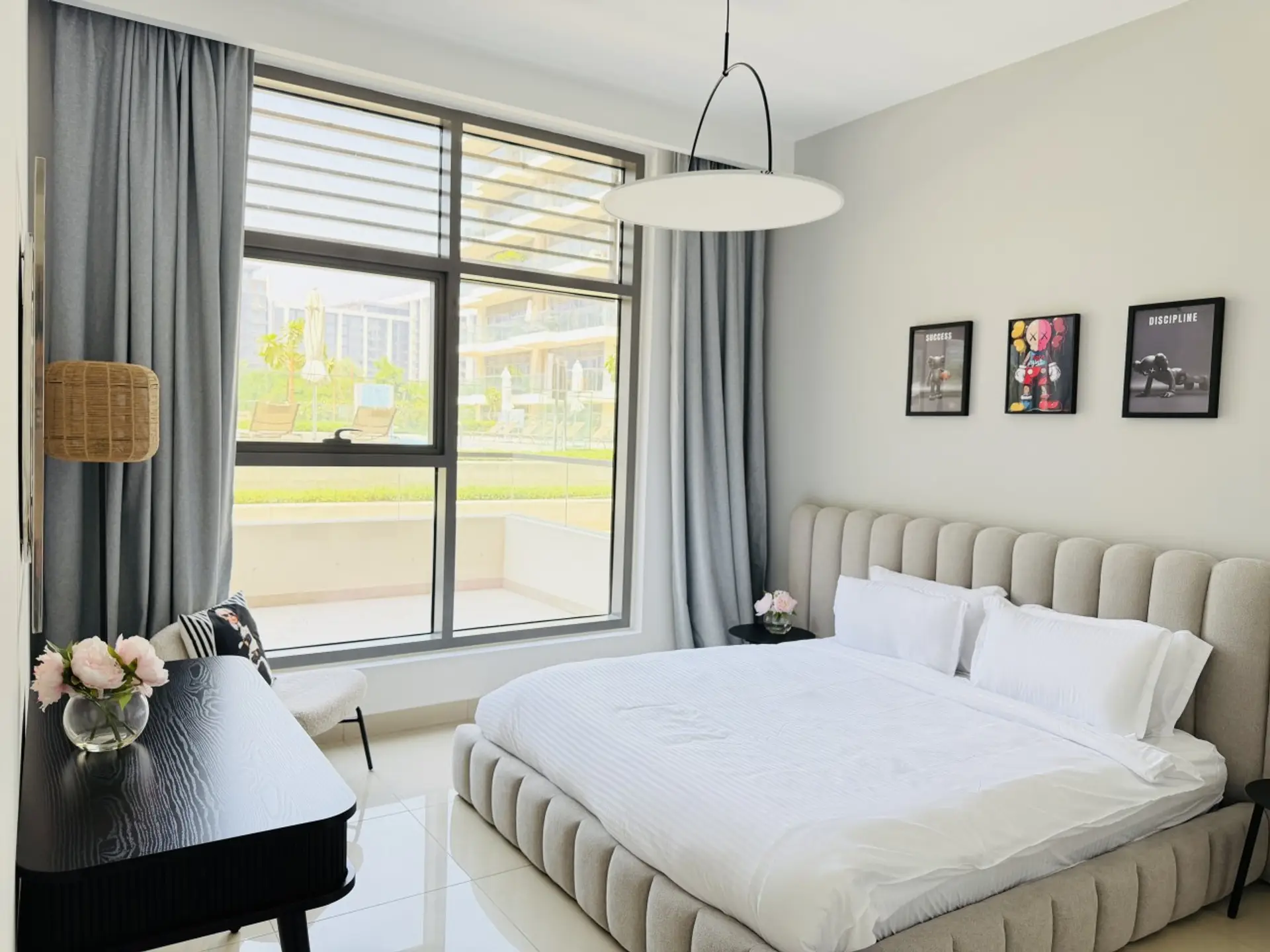 Main sleeping space with a king-size bed, padded headboard and windows facing the garden.