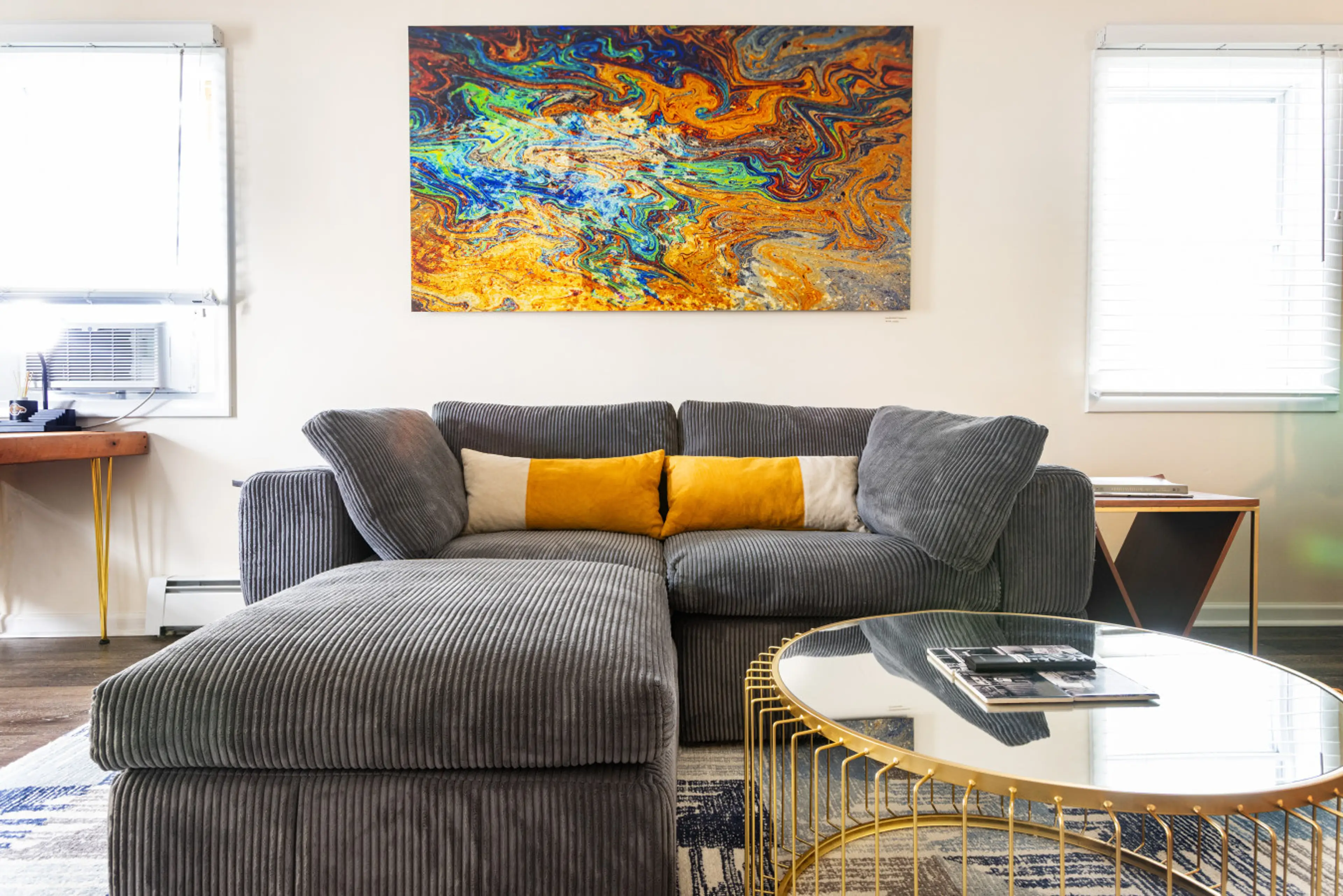 Living room couch with original modern art photography and office space.