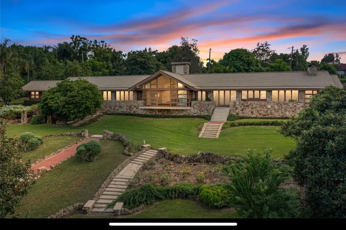 The Luxury Spa Suite building at dusk, with lit windows above terraced lawns at Lakeview Gardens