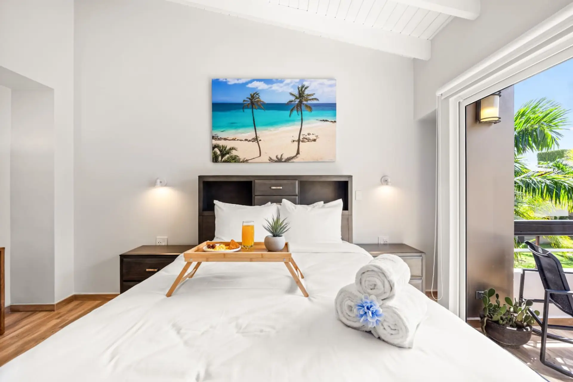 King-size bed, tropical decor, and access to a private balcony.