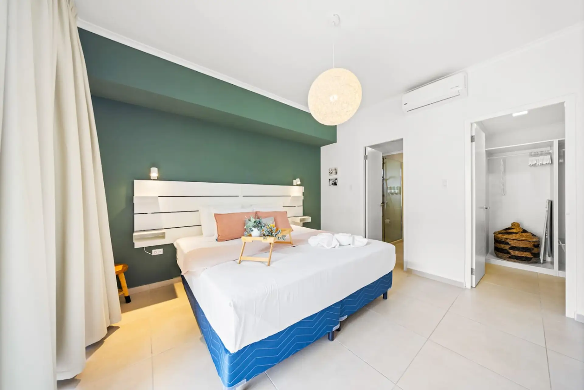 King bed, accent wall, and open closet with plenty of storage space.
