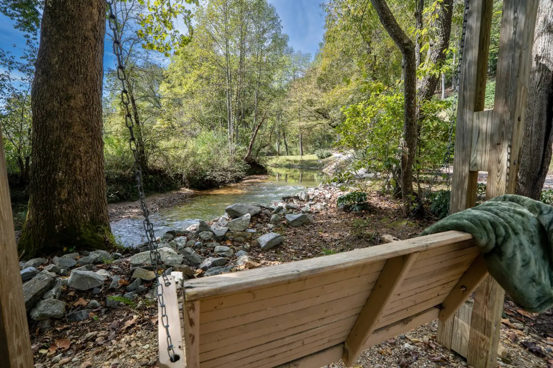 Peaceful swing area beside the creek for quiet moments outdoors.