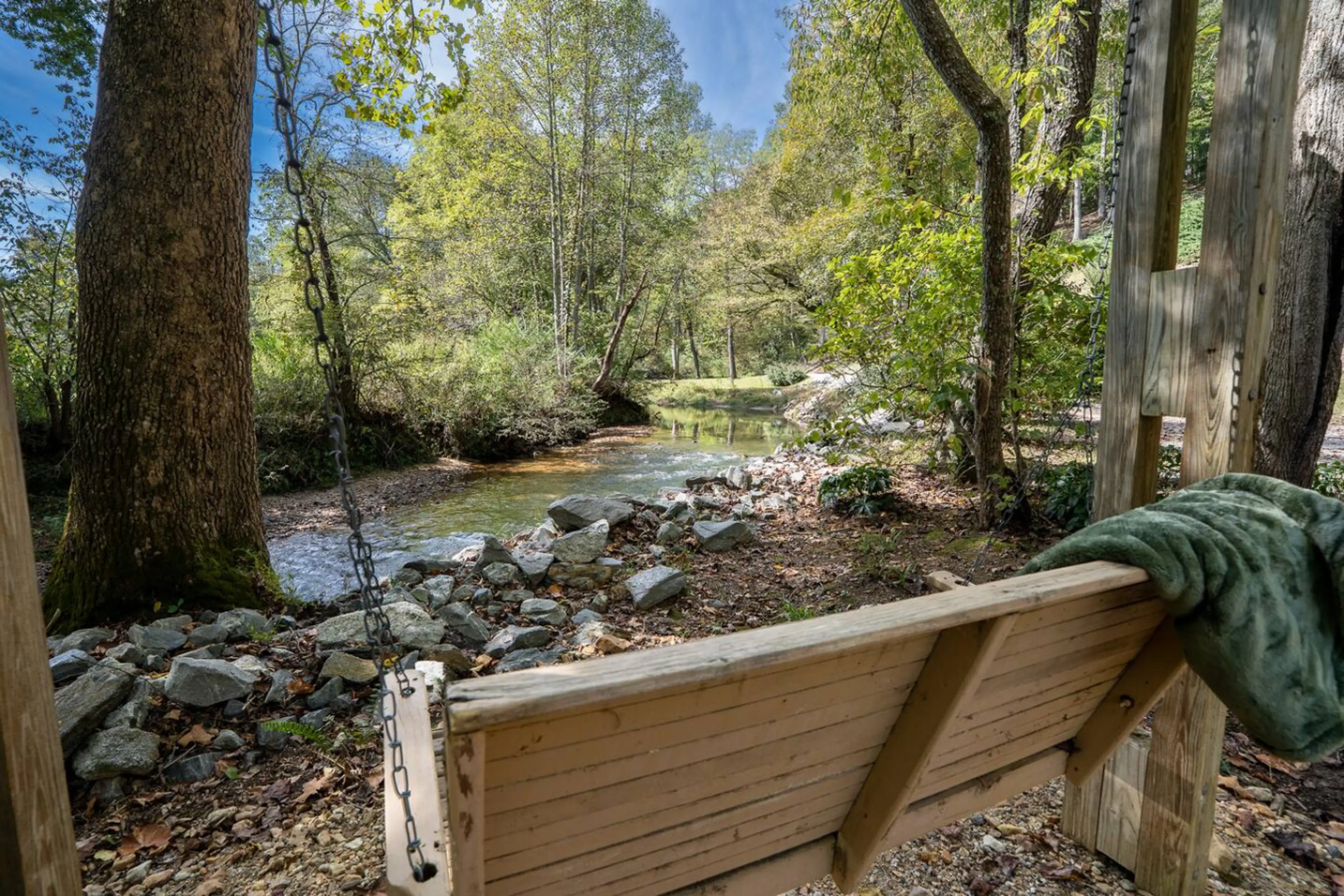 Peaceful swing area beside the creek for quiet moments outdoors.