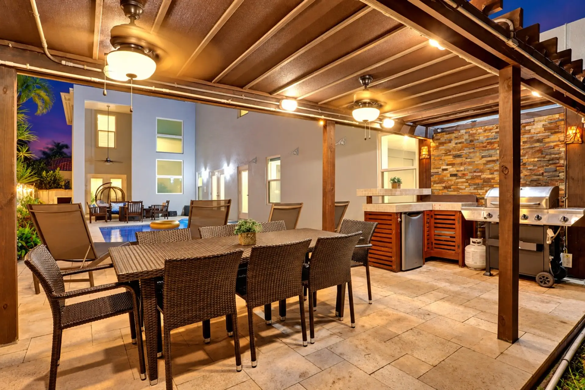 Gather around the spacious covered outdoor dining area, complete with a full outdoor kitchen and easy access to the pool—perfect for evening meals and relaxing together. ✨