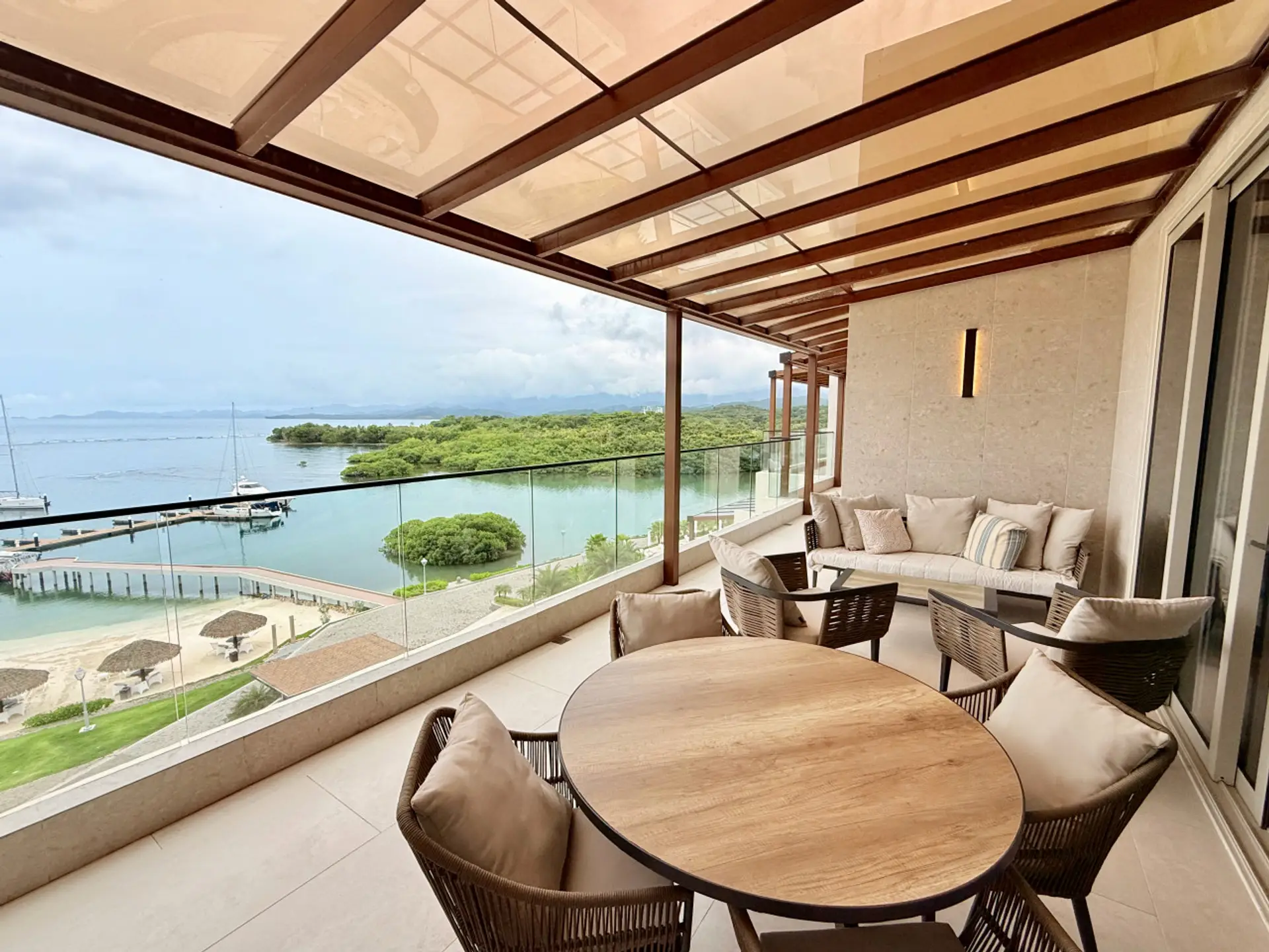 Expansive penthouse balcomy with outdoor dining and lounge seating, offering direct, unobstructed ocean views.