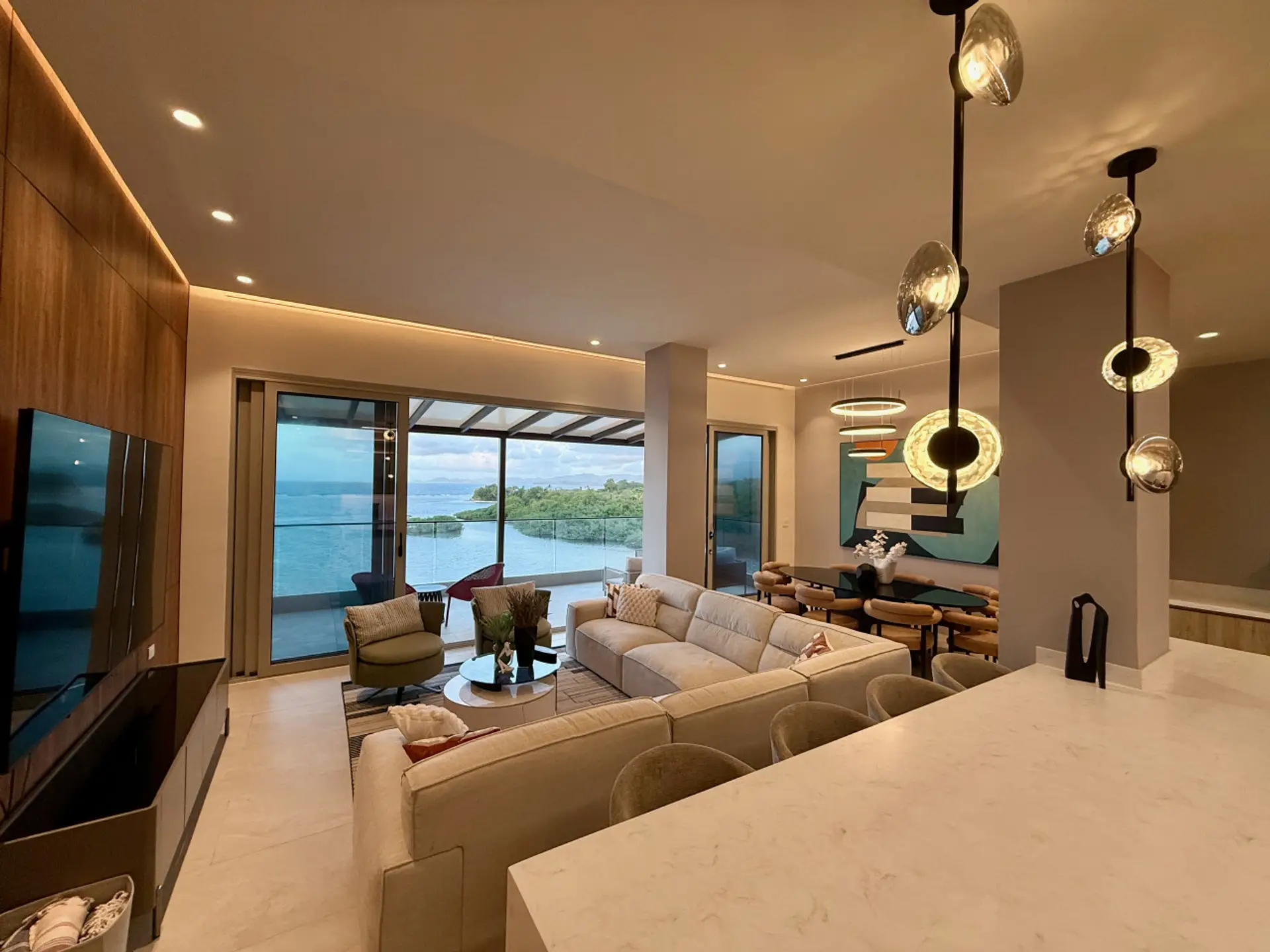 Spacious designer living room featuring a 100" TV and panoramic marina and sea views