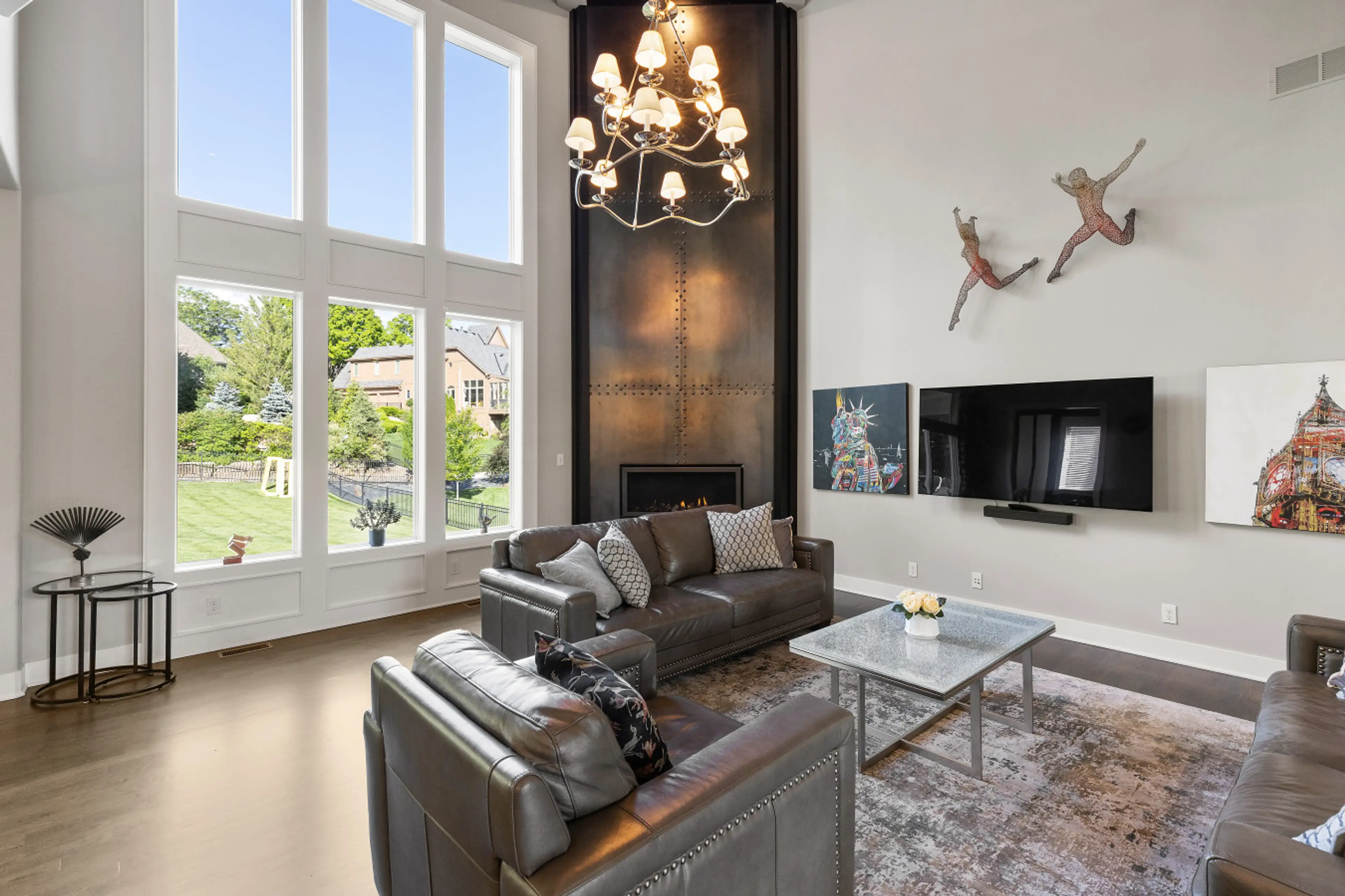 Relax in a sun-filled living room with soaring ceilings, oversized windows, and a stylish fireplace—perfect for gathering and unwinding.