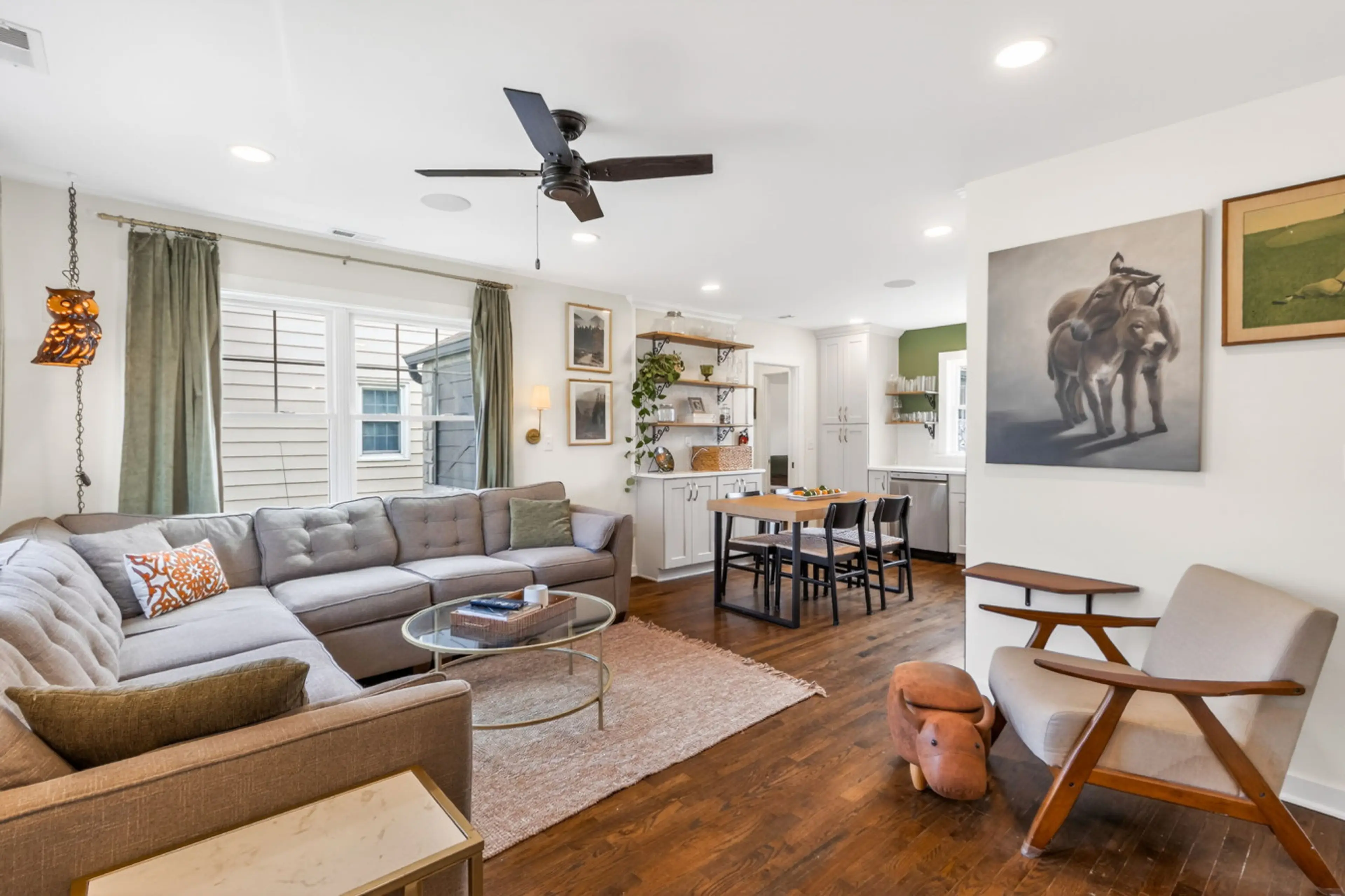 A warm, open-concept living space with cozy seating, natural light, and a seamless flow into the dining area—perfect for relaxing or entertaining.