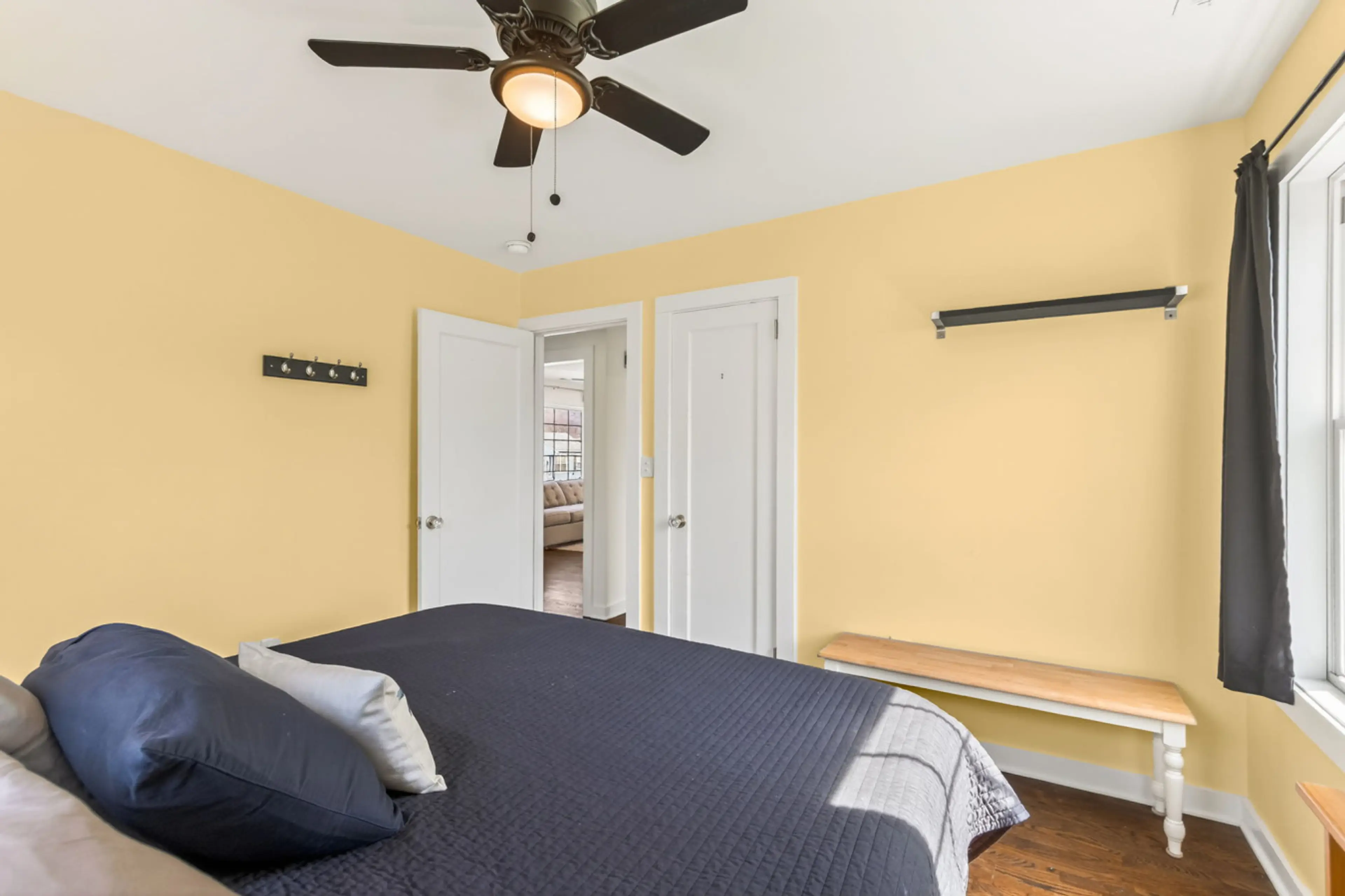 A cheerful bedroom with soft yellow walls, simple furnishings, and a calm atmosphere ideal for restful nights.
