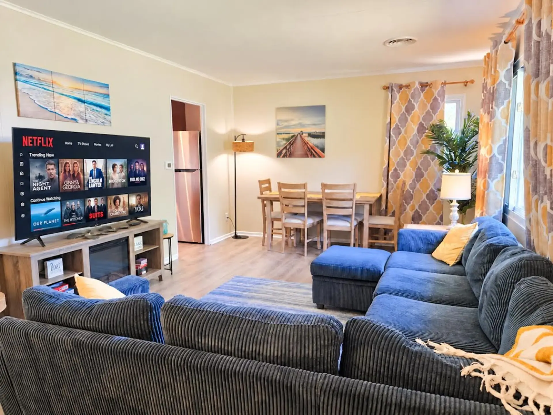 Relax together in the spacious living room with comfortable seating, a large smart TV, and room for shared meals.
