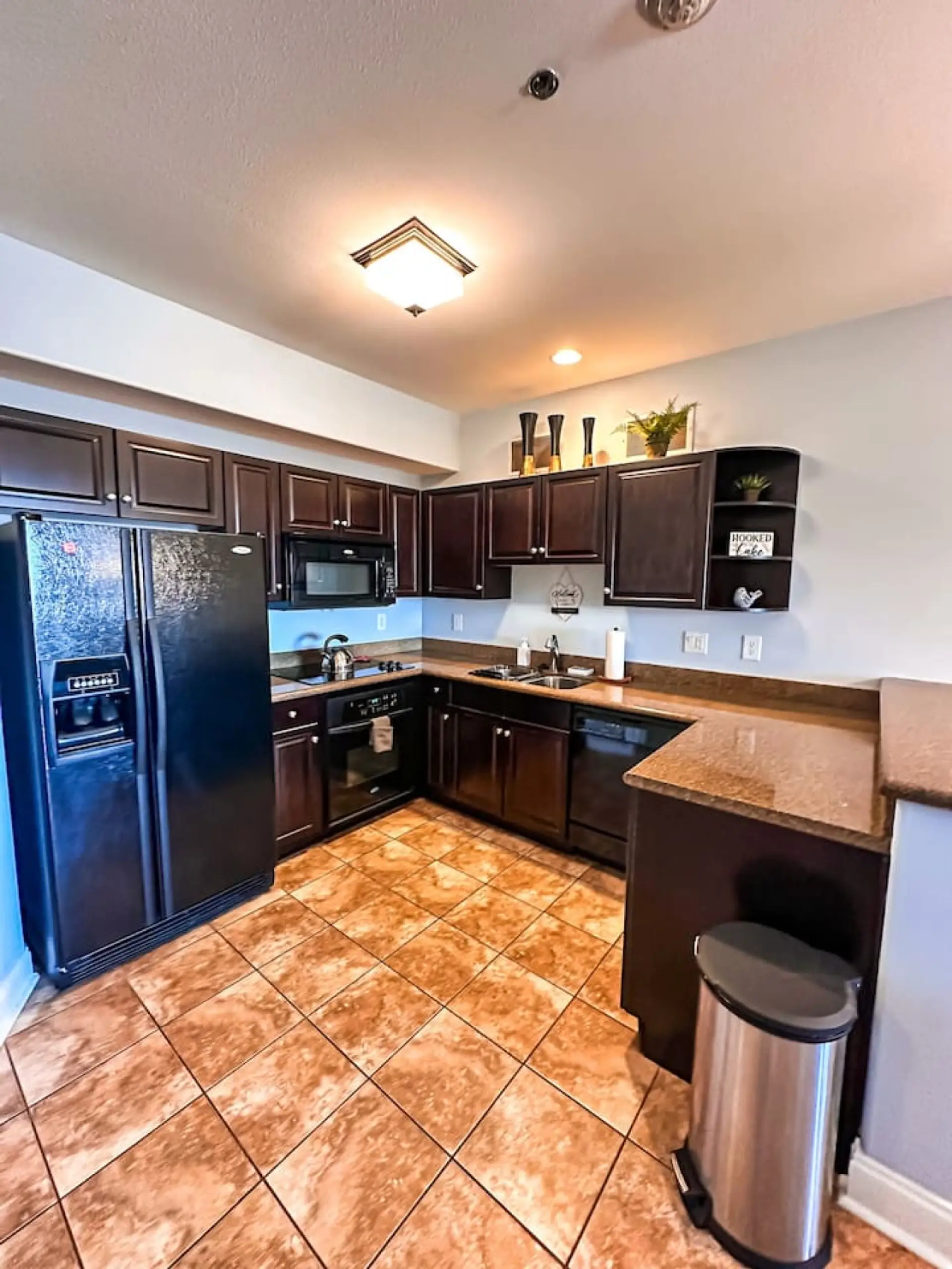 Spacious countertops and dark wood cabinets make this kitchen both functional and stylish—perfect for creating delicious meals.