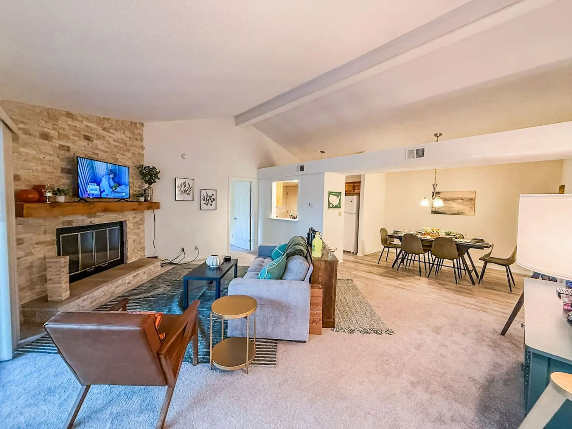 This inviting living area features a charming brick fireplace, perfect for cozy evenings, and flows seamlessly into a dedicated dining space. The open-concept layout and neutral tones create a bright and versatile environment, ready for your personal