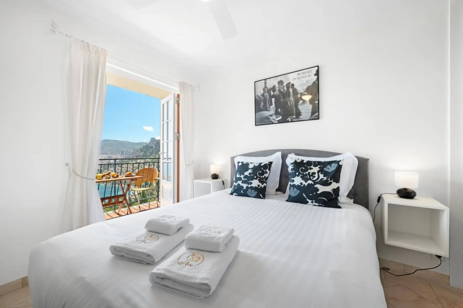 Une chambre cosy avec vue sur l’océan, lumière chaude, invitant au repos.