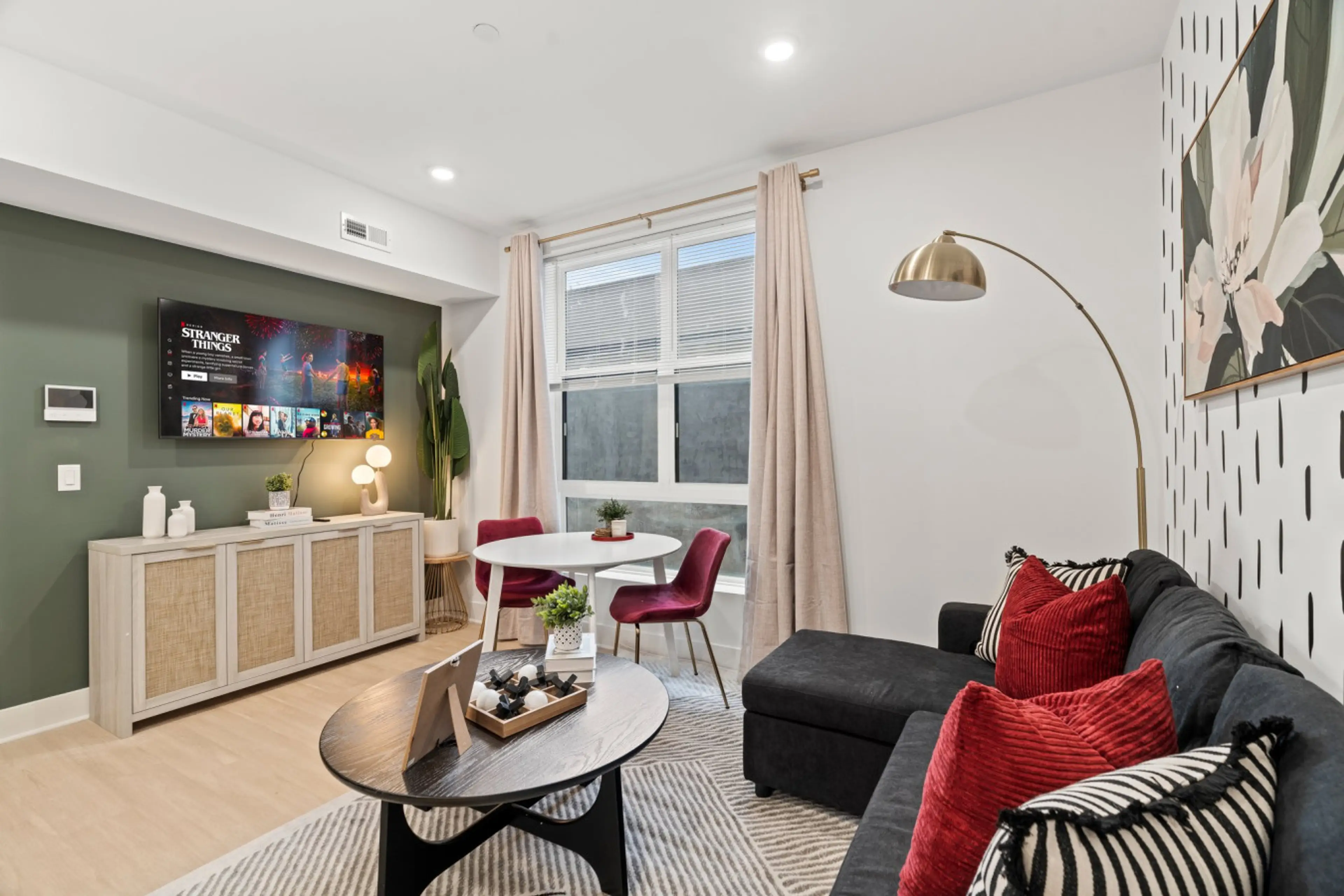 Bright living room with smart TV, cozy seating, and modern décor