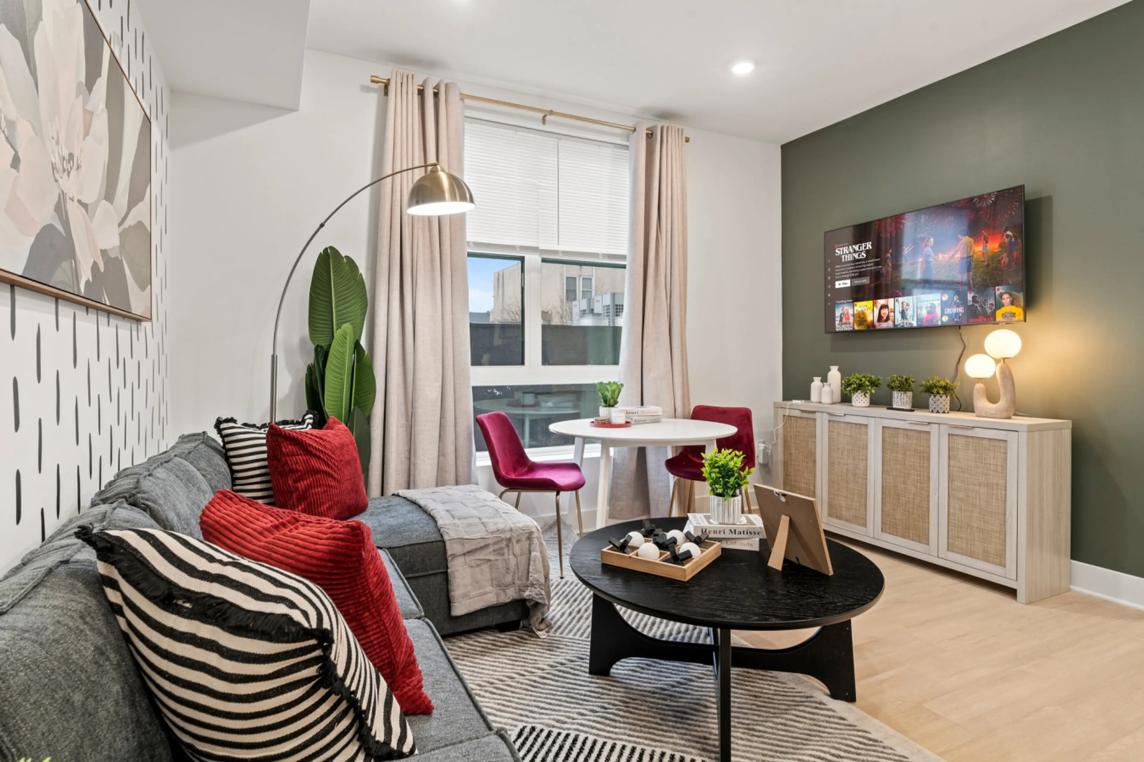 Relax in this sun-drenched living area featuring a designer sofa and 4K Smart TV—perfect for movie nights after exploring the city.