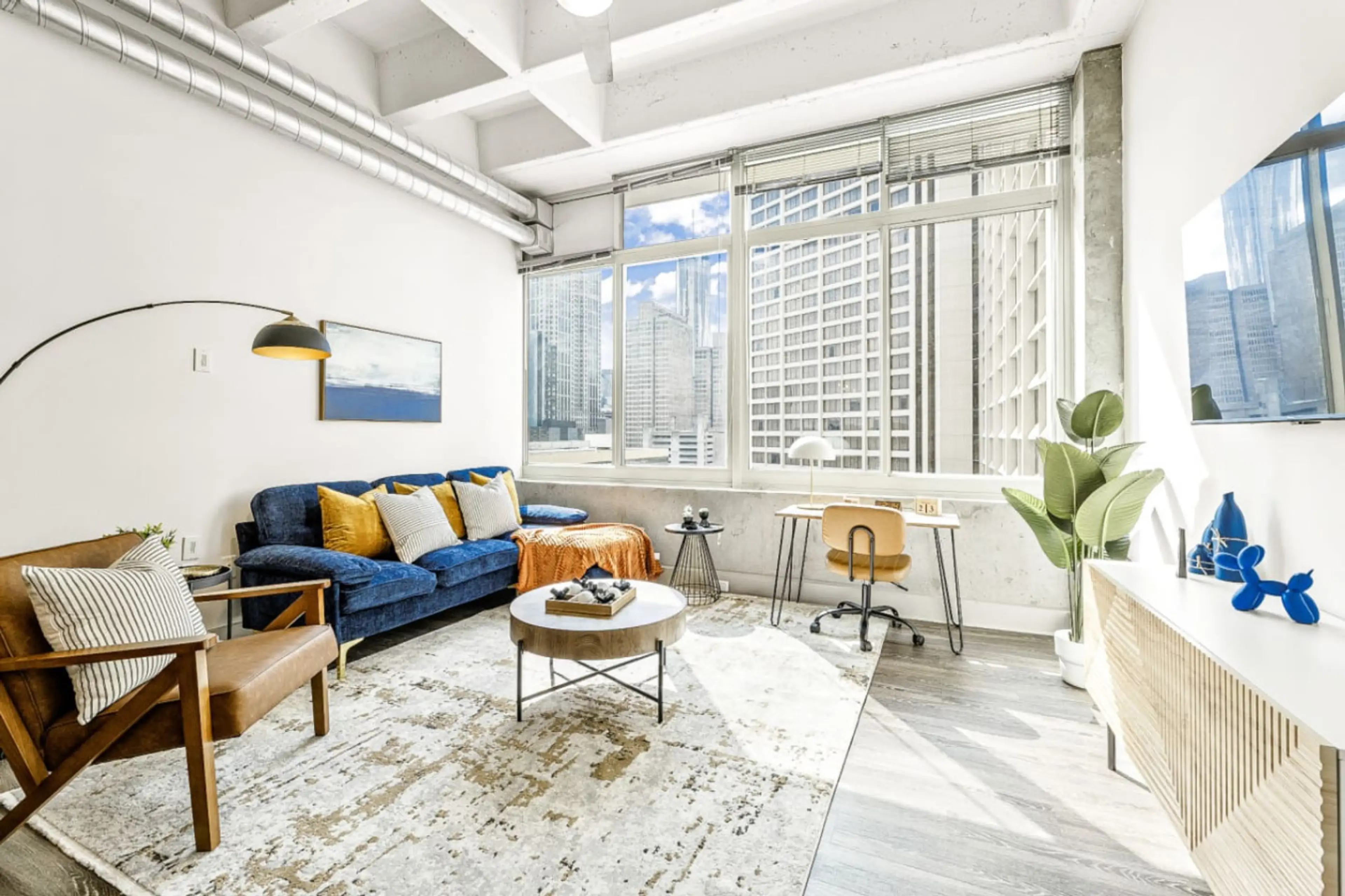 Living Room Oasis: Bask in vibrant city views and chic decor in this stylish urban escape!