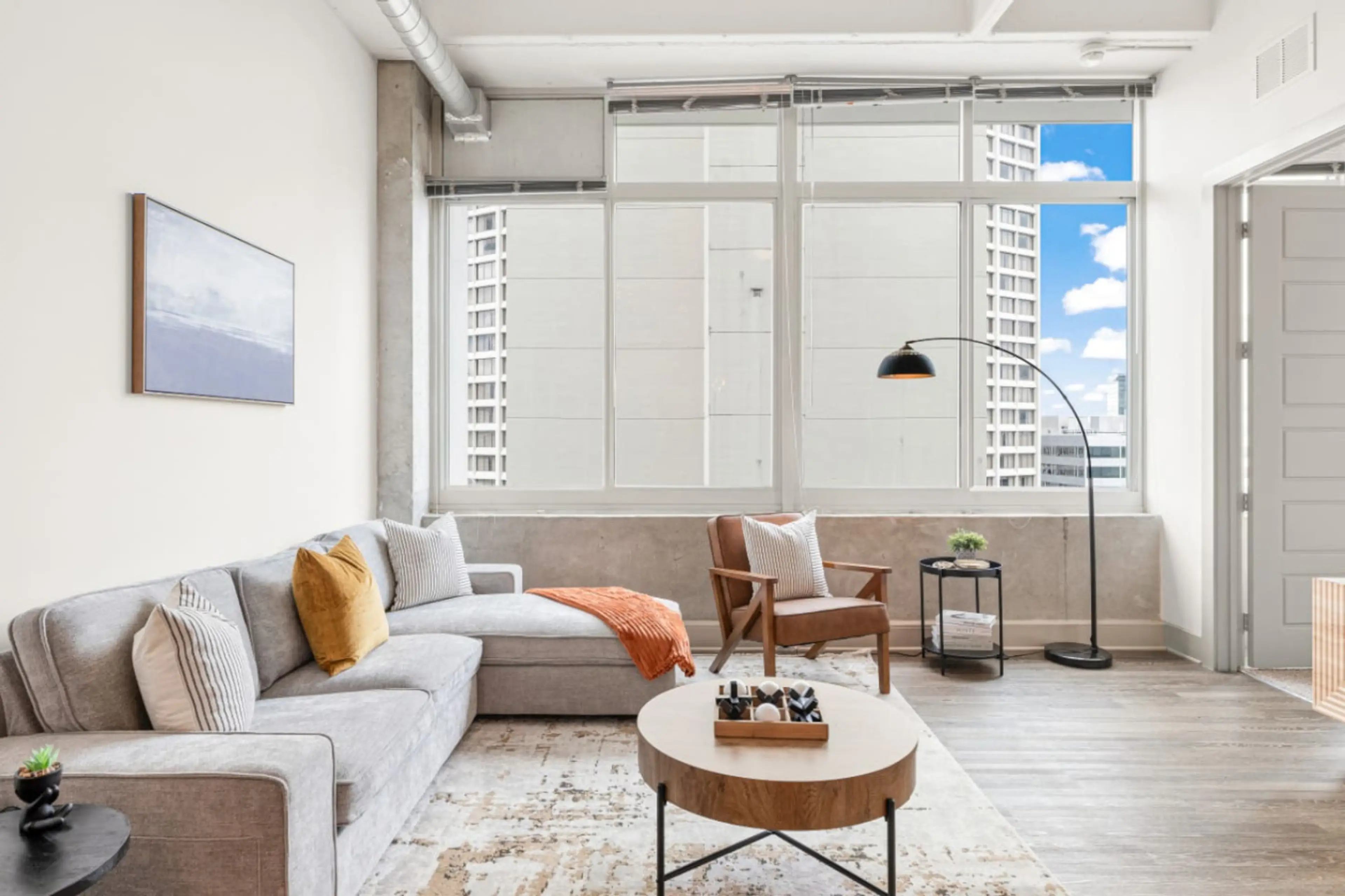 Living Room: Chic space filled with light, featuring stylish seating and vibrant city views!