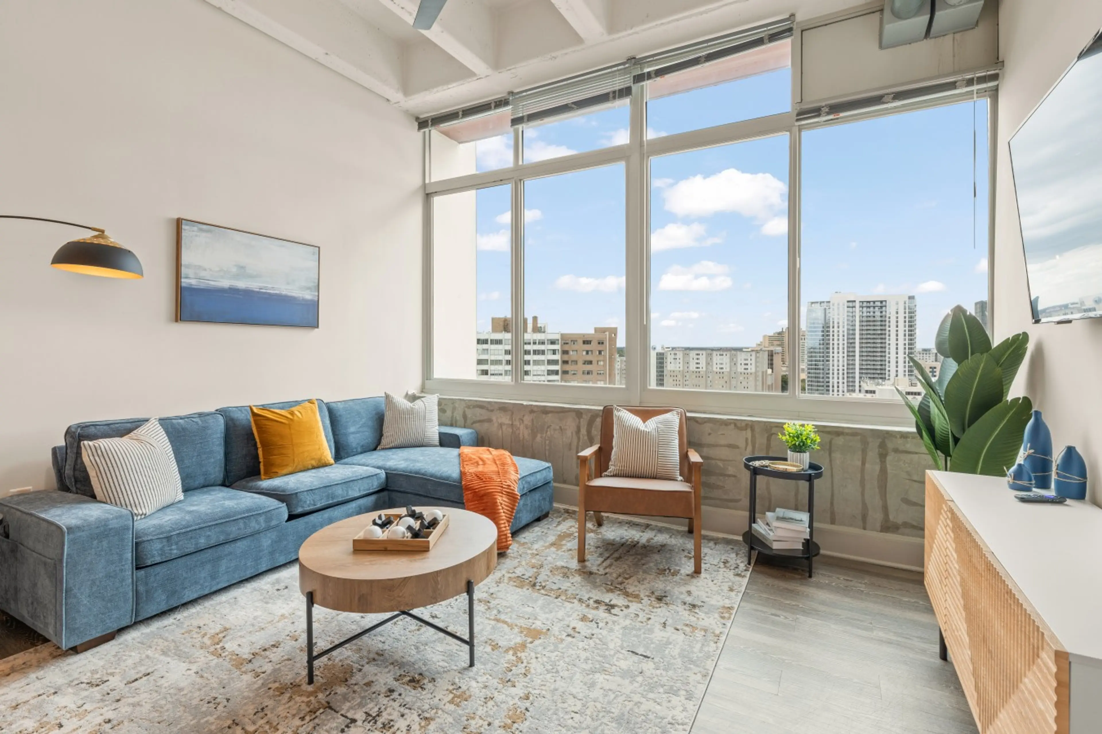 elax in a stylish living room with floor-to-ceiling windows and city views.