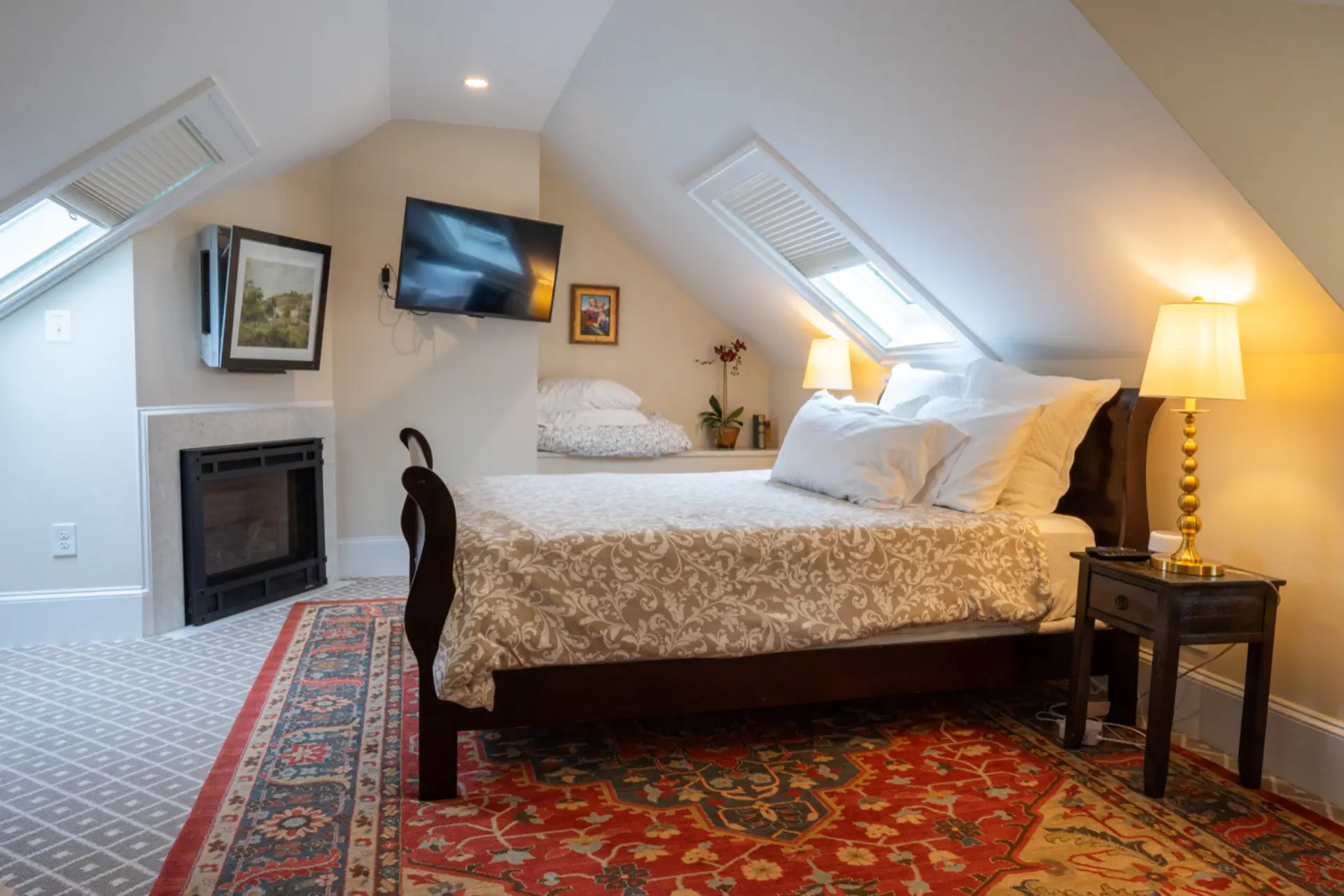 Light-filled bedroom with a queen bed, cozy textures, and attic-level charm.