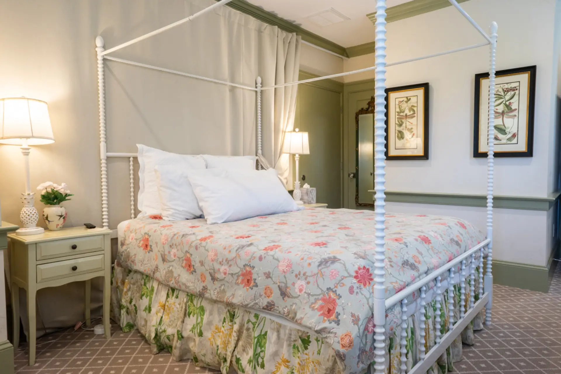 A classic four-poster queen bed dressed in soft florals creates a romantic, garden-inspired retreat.