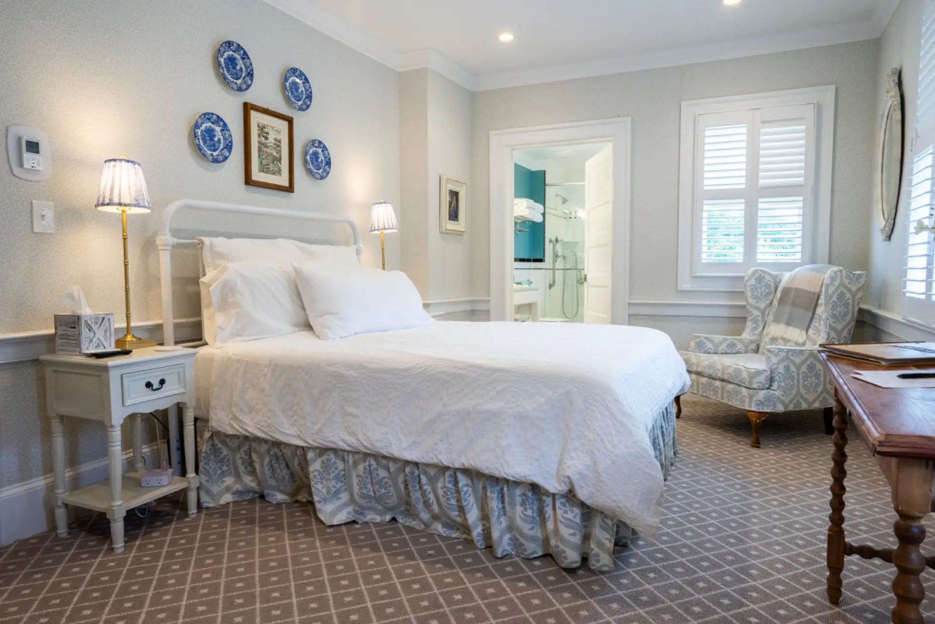 A bright and welcoming bedroom with an adjustable queen bed, soft blue accents, and classic farmhouse charm.