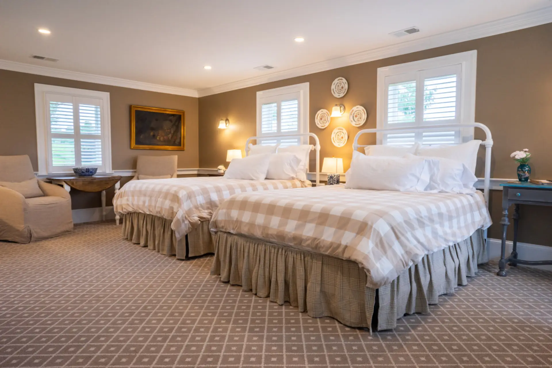 A spacious, light-filled room featuring two comfortable queen beds and classic farmhouse style.
