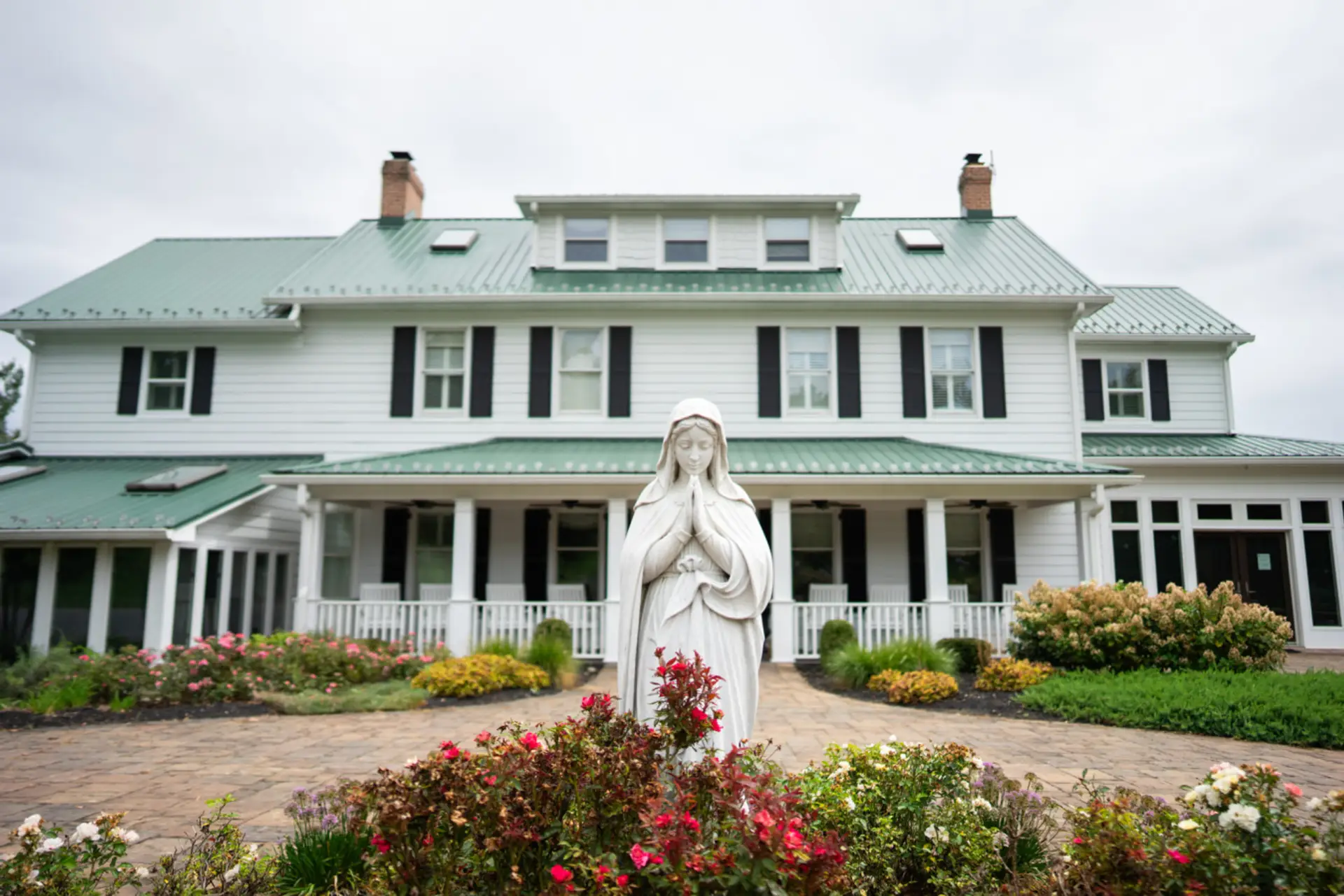 The historic inn welcomes guests with manicured gardens and timeless farmhouse charm.