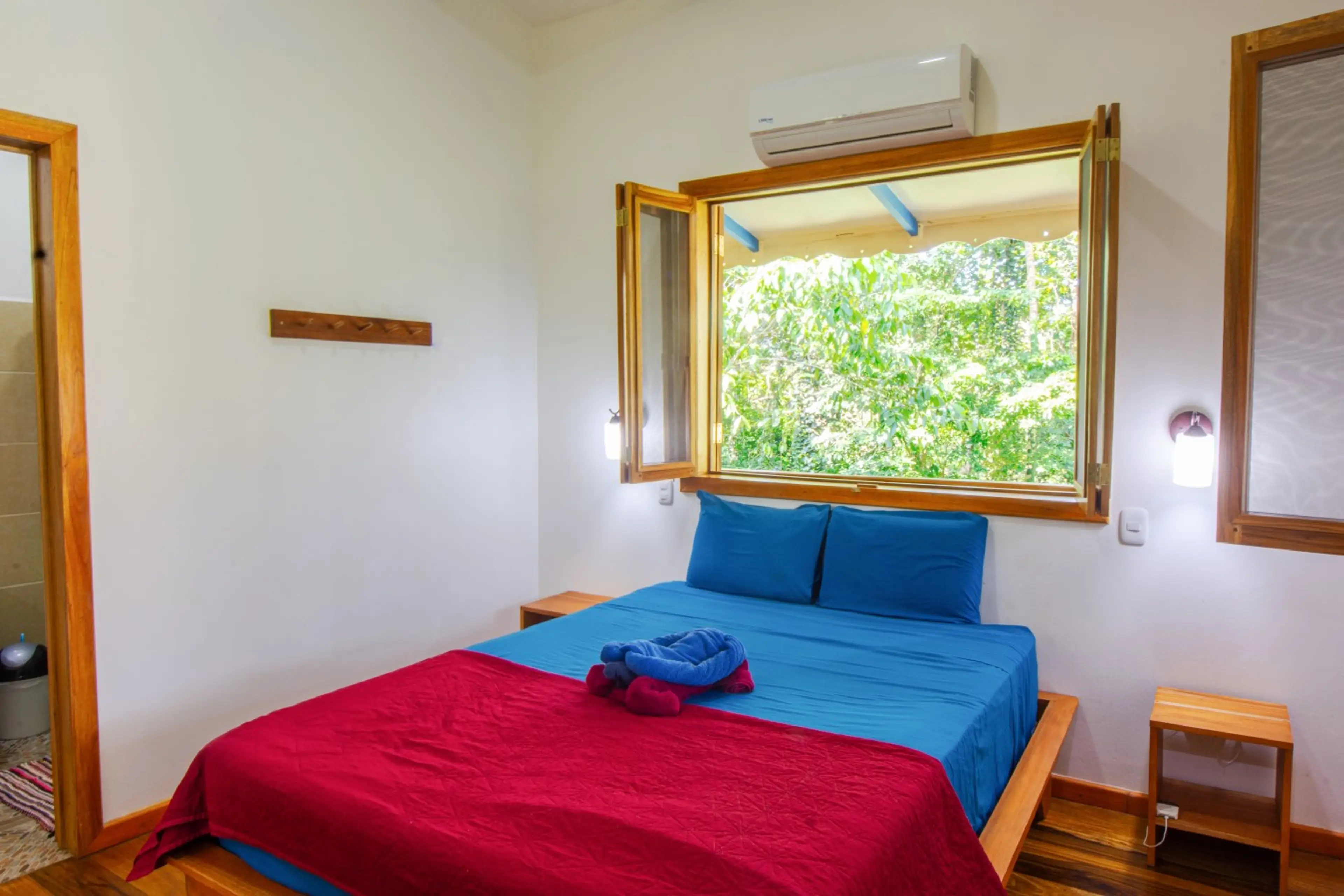 Air-conditioned main bedroom with queen bed, natural light, and peaceful jungle views, Blue Maverick in Puerto Viejo