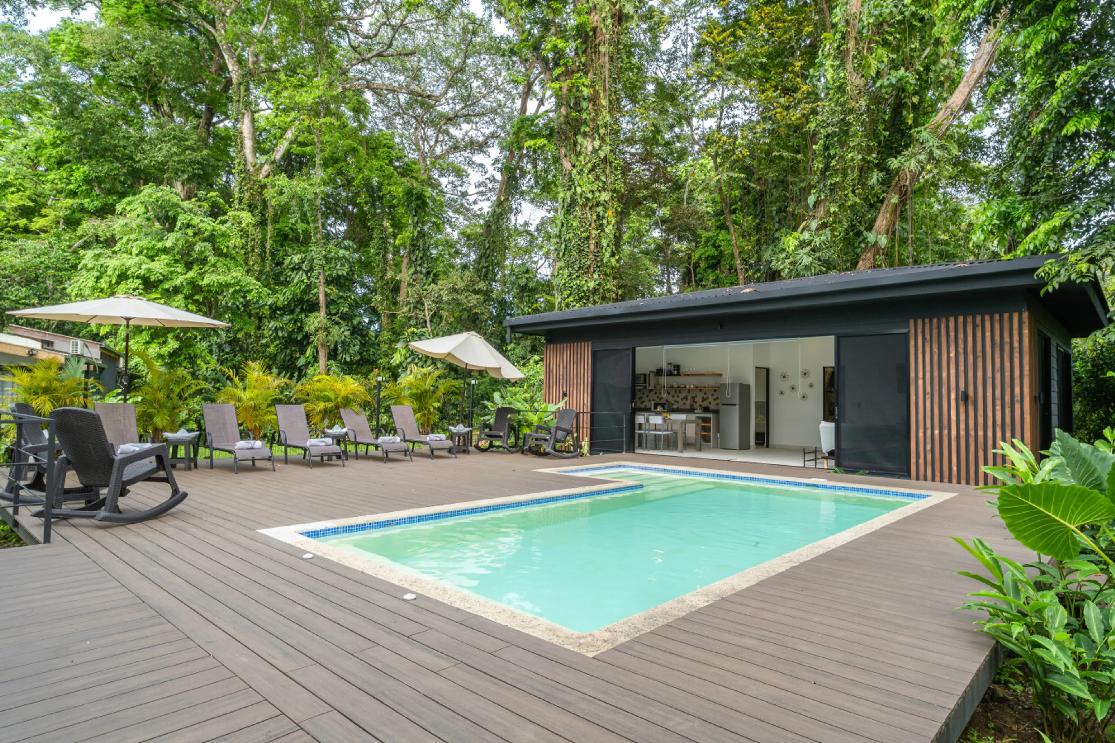 Modern tropical villa with shared swimming pool surrounded by lush rainforest at Somnara Flor Silvestre, Playa Chiquita, Costa Rica