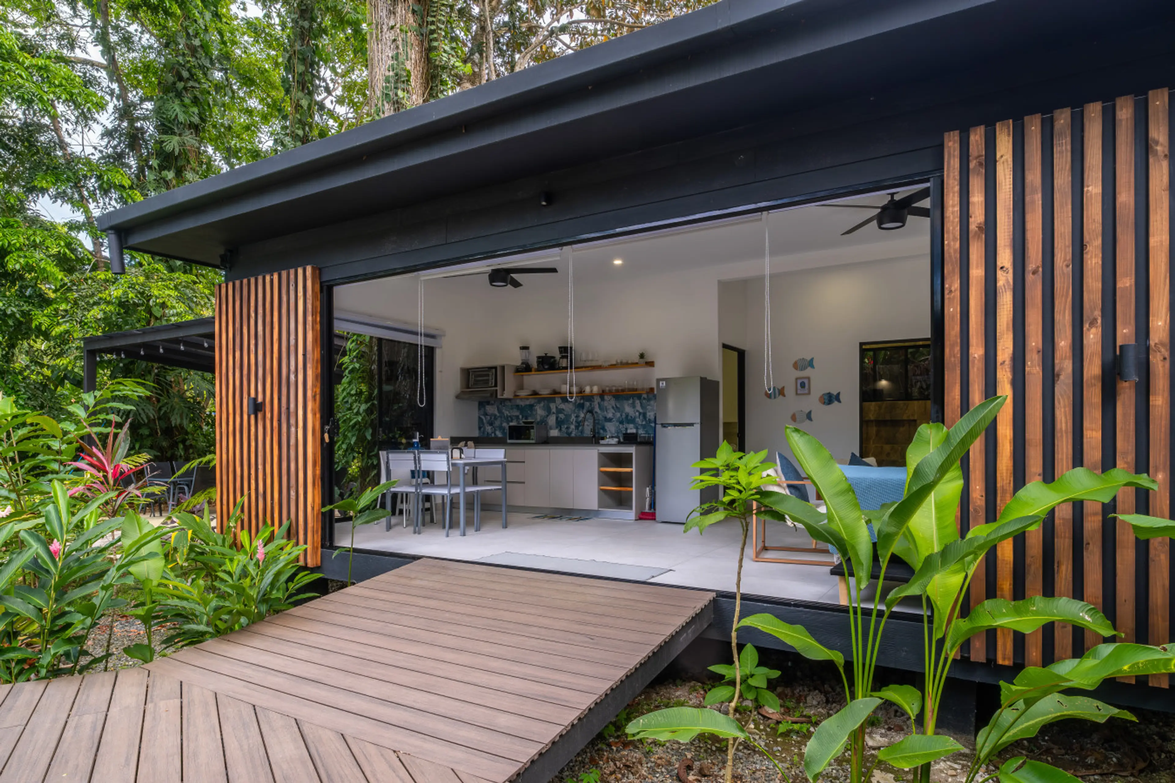 Modern tropical villa exterior with open-concept living space and lush jungle surroundings at Somnara Espuma de Mar, Playa Chiquita, Costa Rica