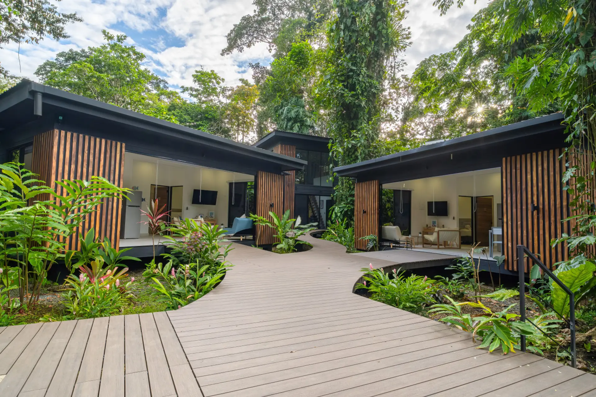 Modern tropical villas connected by elevated wooden walkways at Somnara Botánica, Playa Chiquita, Costa Rica
