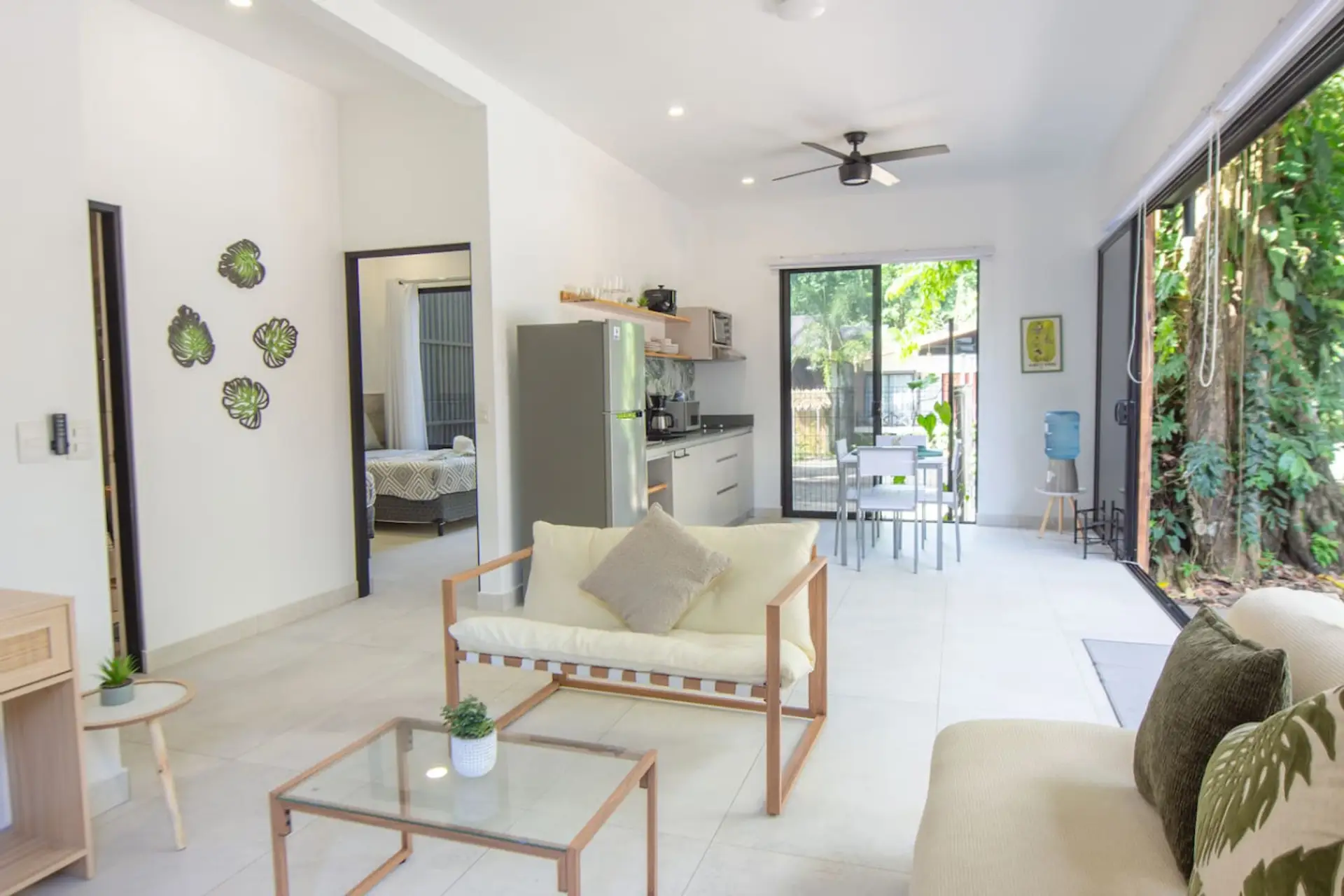 Bright open-concept living area with cozy seating at Somnara Casa Botánica, Playa Chiquita, Costa Rica.