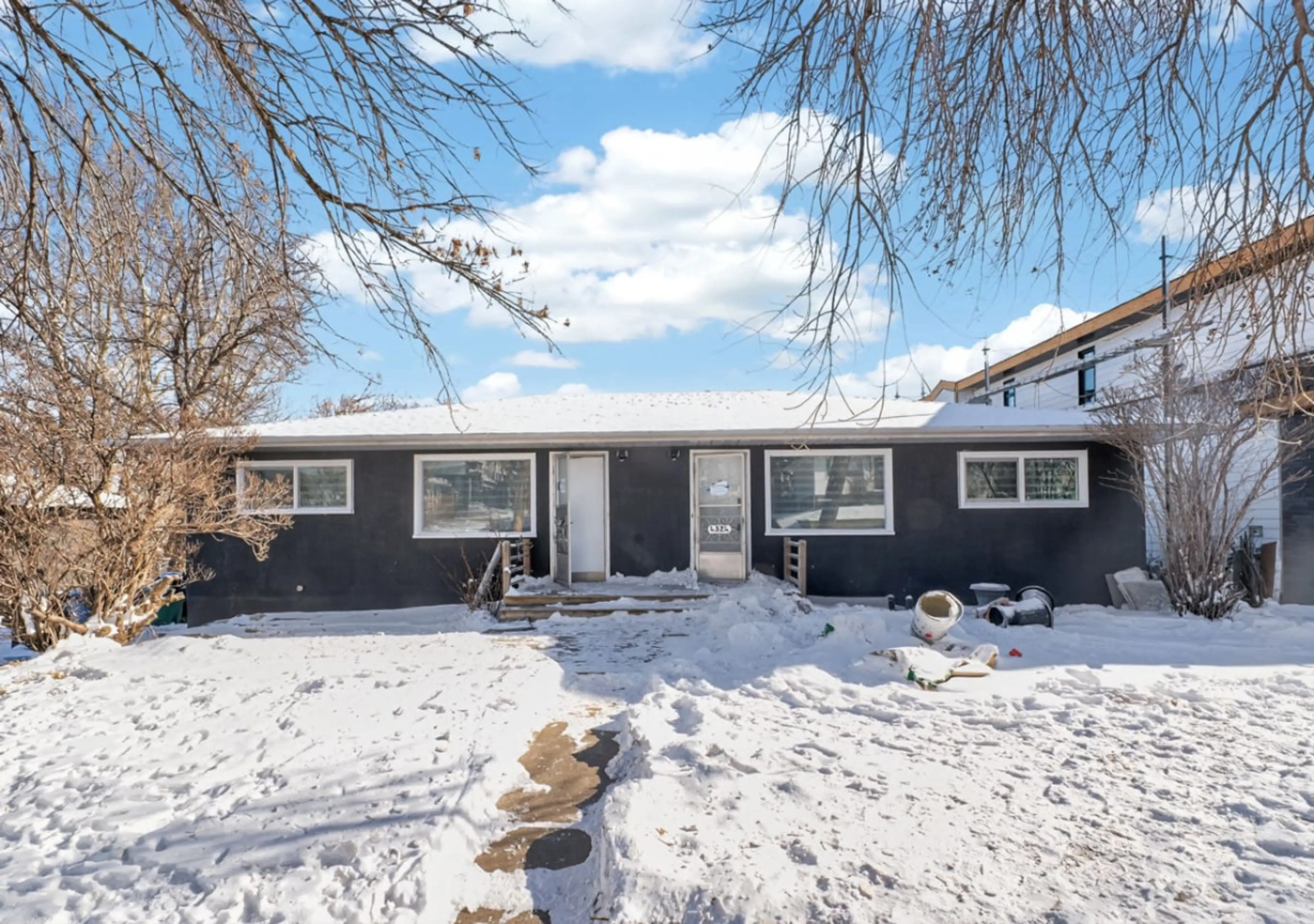 Bright and spacious living area with comfortable sectional sofa and large wall-mounted TV.