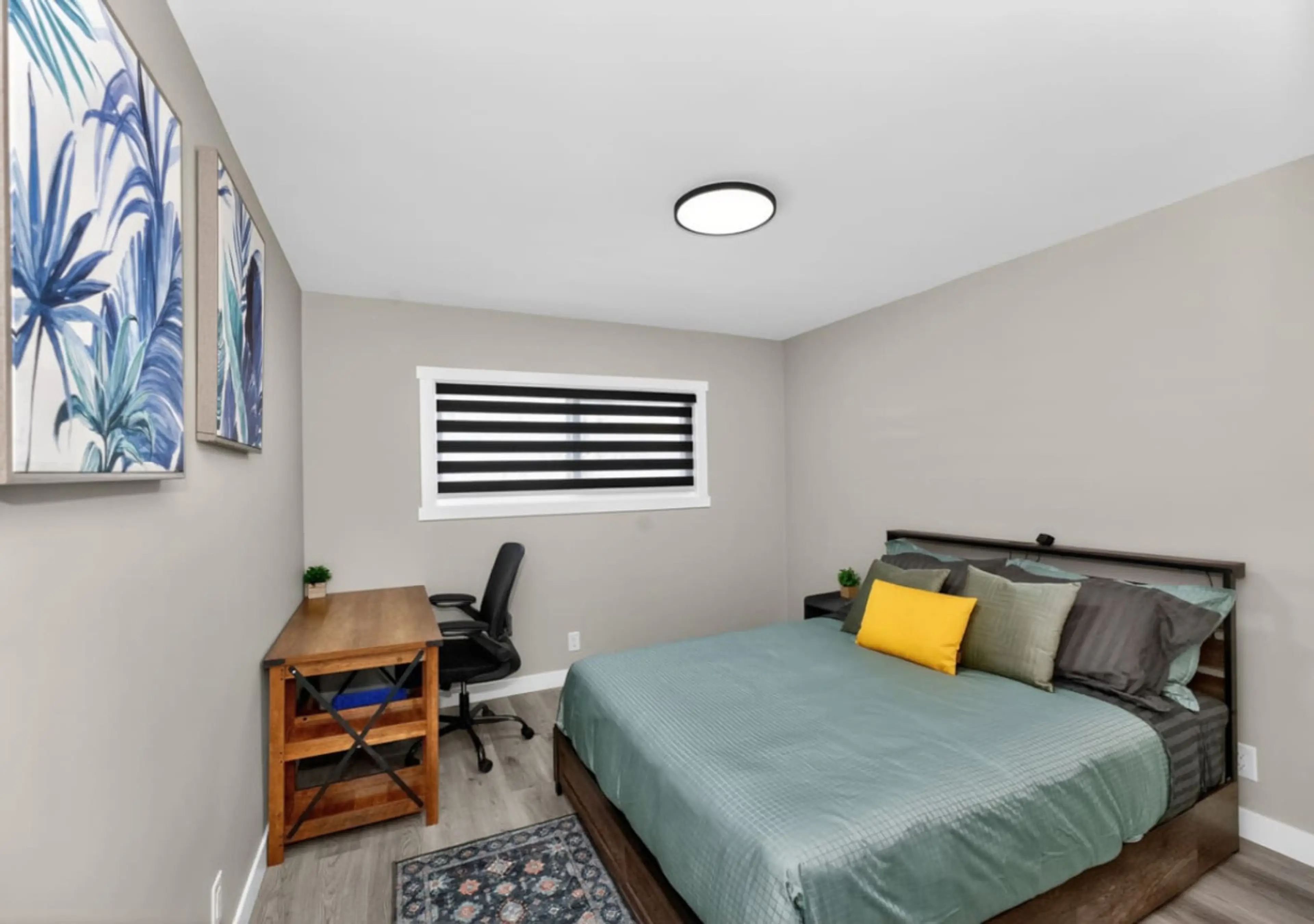 Comfortable bedroom with workspace, blackout blinds, and a relaxing atmosphere for restful nights.
