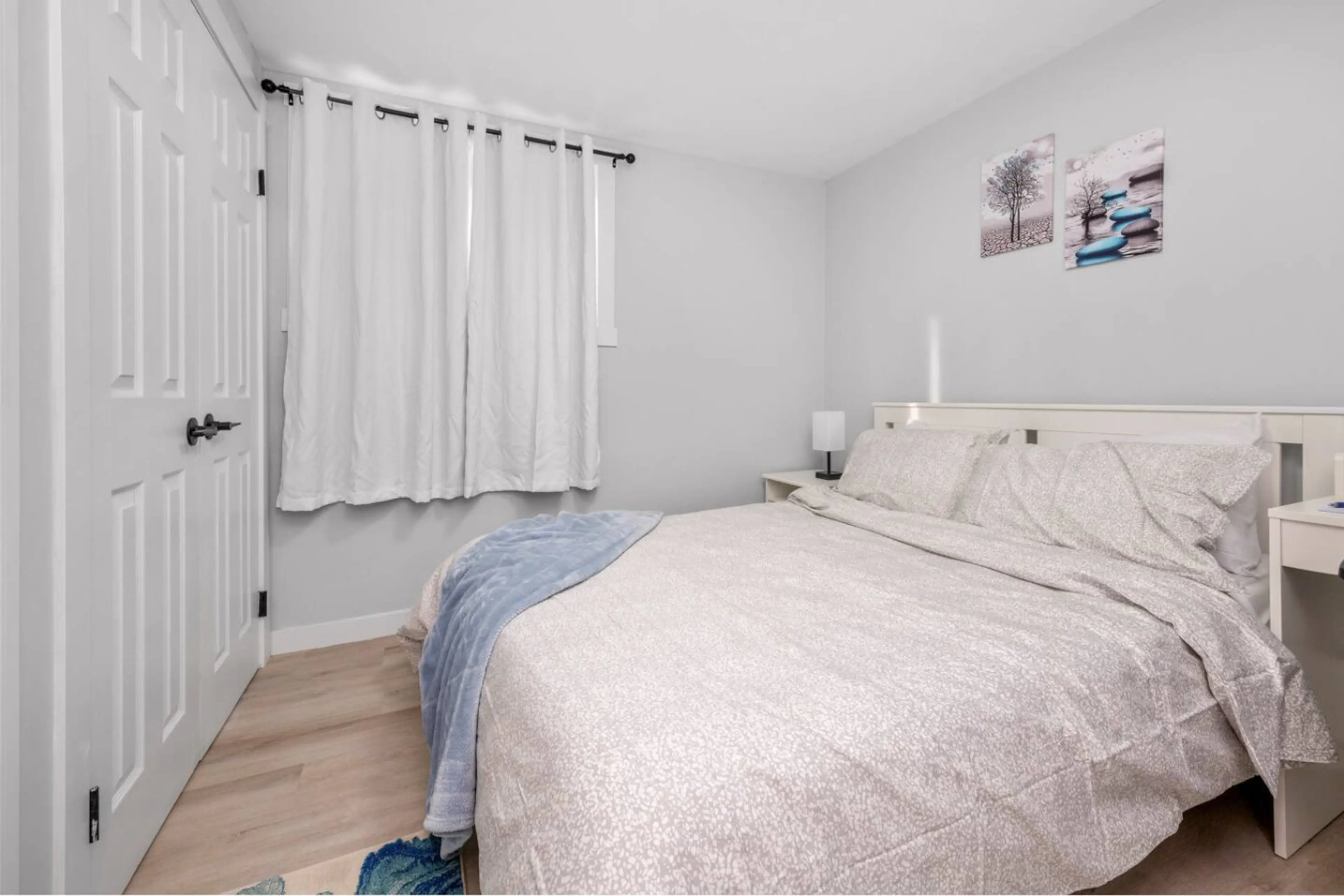 Spacious primary bedroom with soft bedding and a calm, relaxing setting.