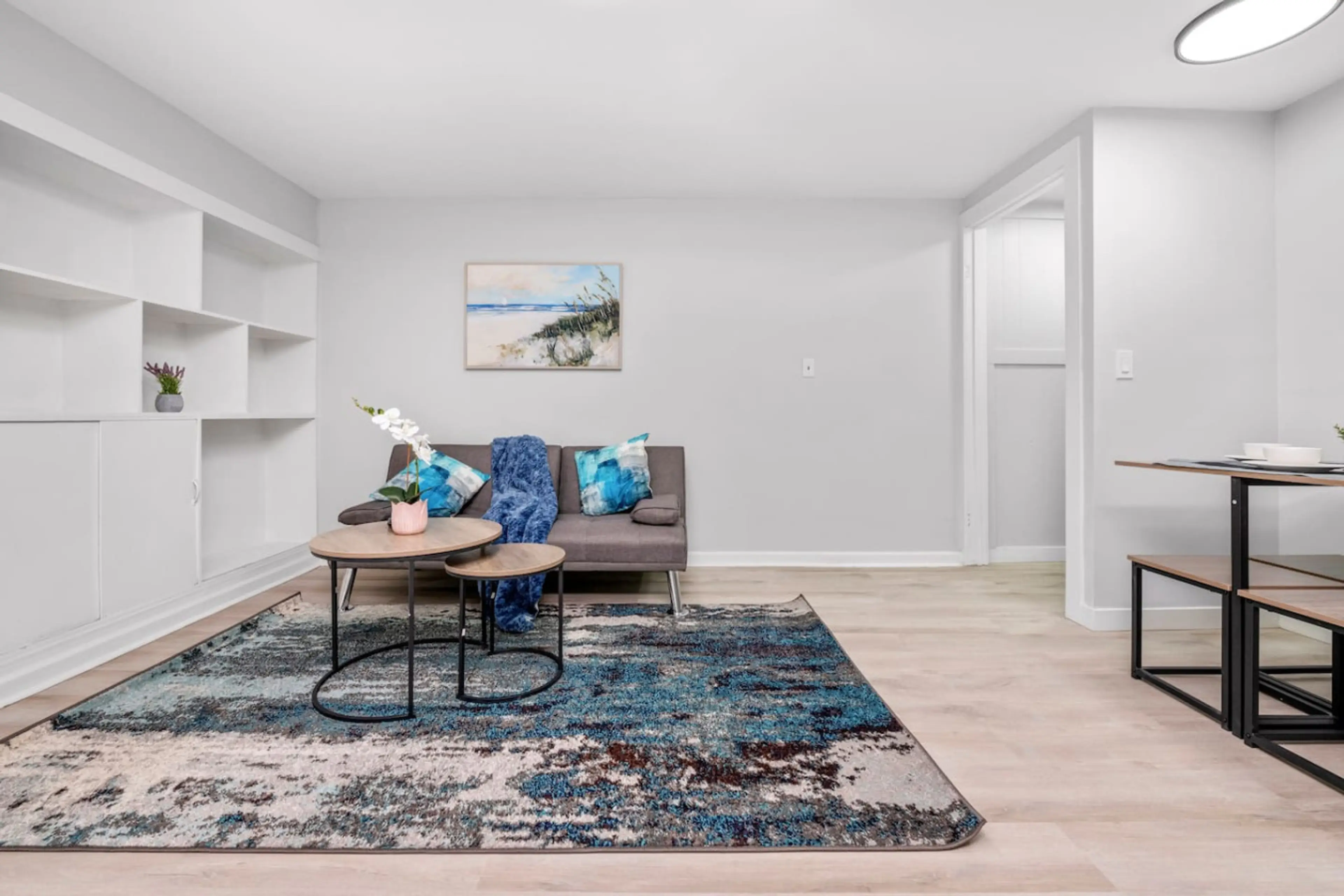 Bright living area with comfortable seating and decorative shelving for a welcoming atmosphere.