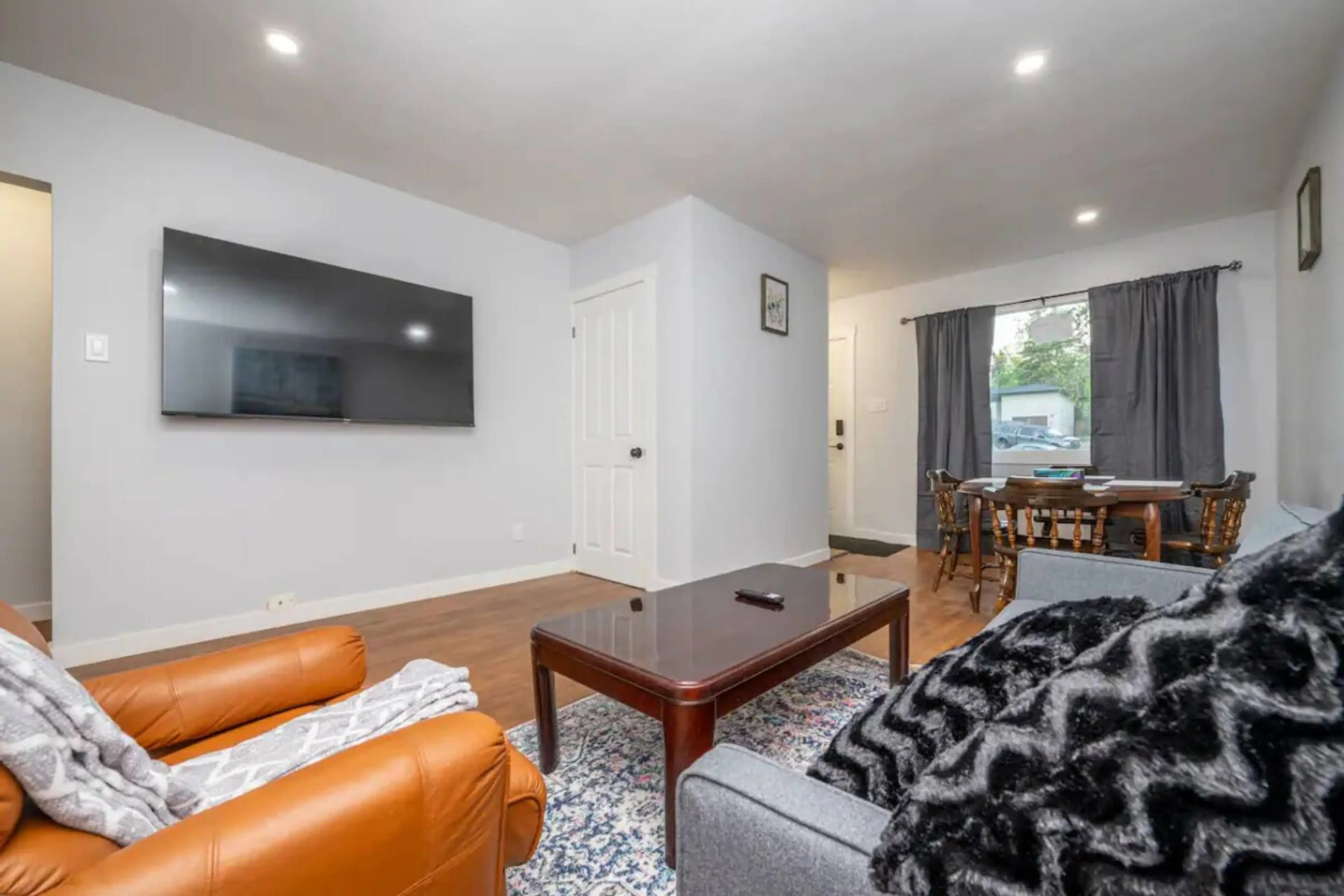 Bright and cozy living room with smart TV, comfortable seating, and plenty of natural light