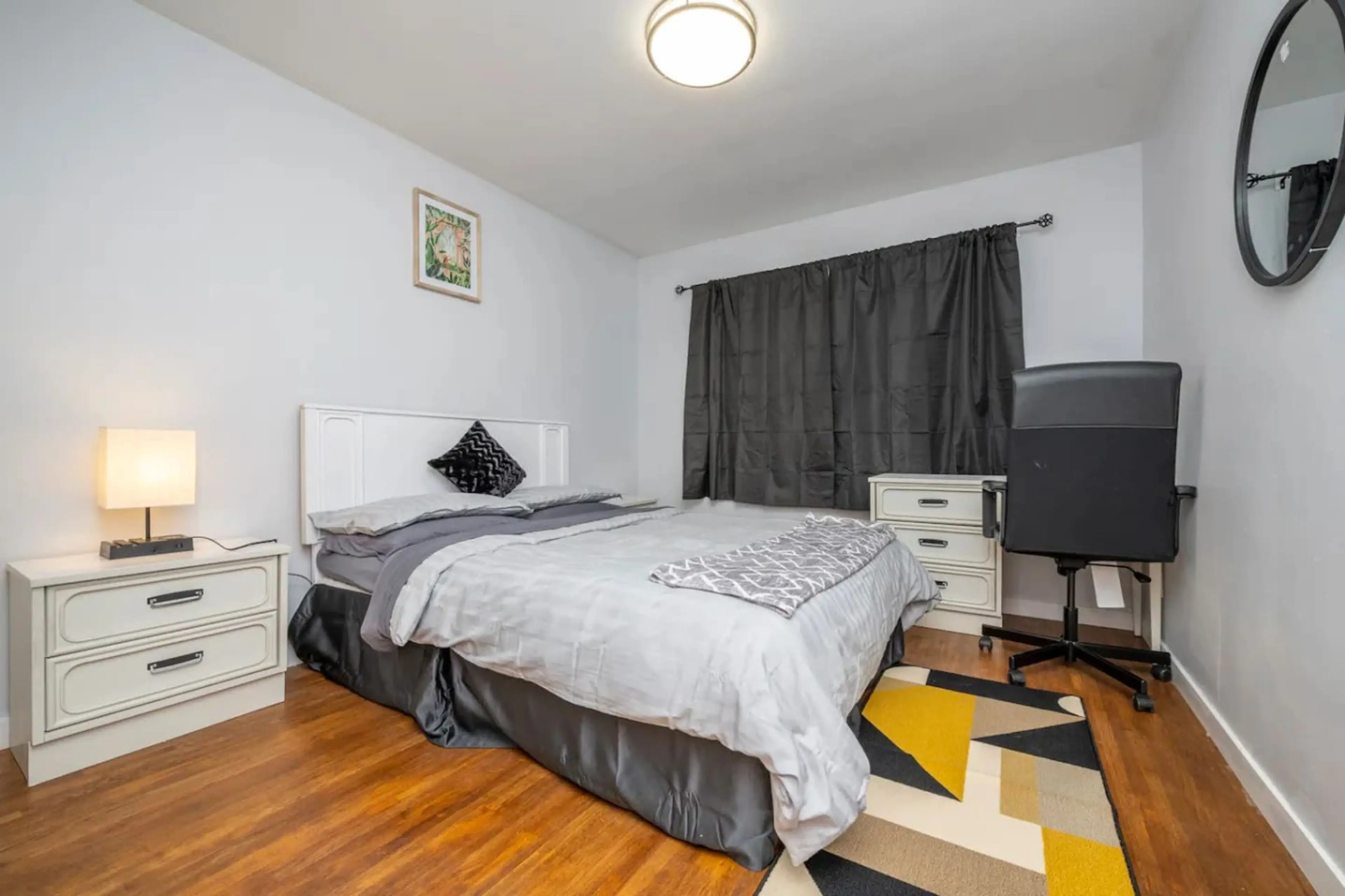 Quiet bedroom with comfortable bed, workspace, and blackout curtains for better rest