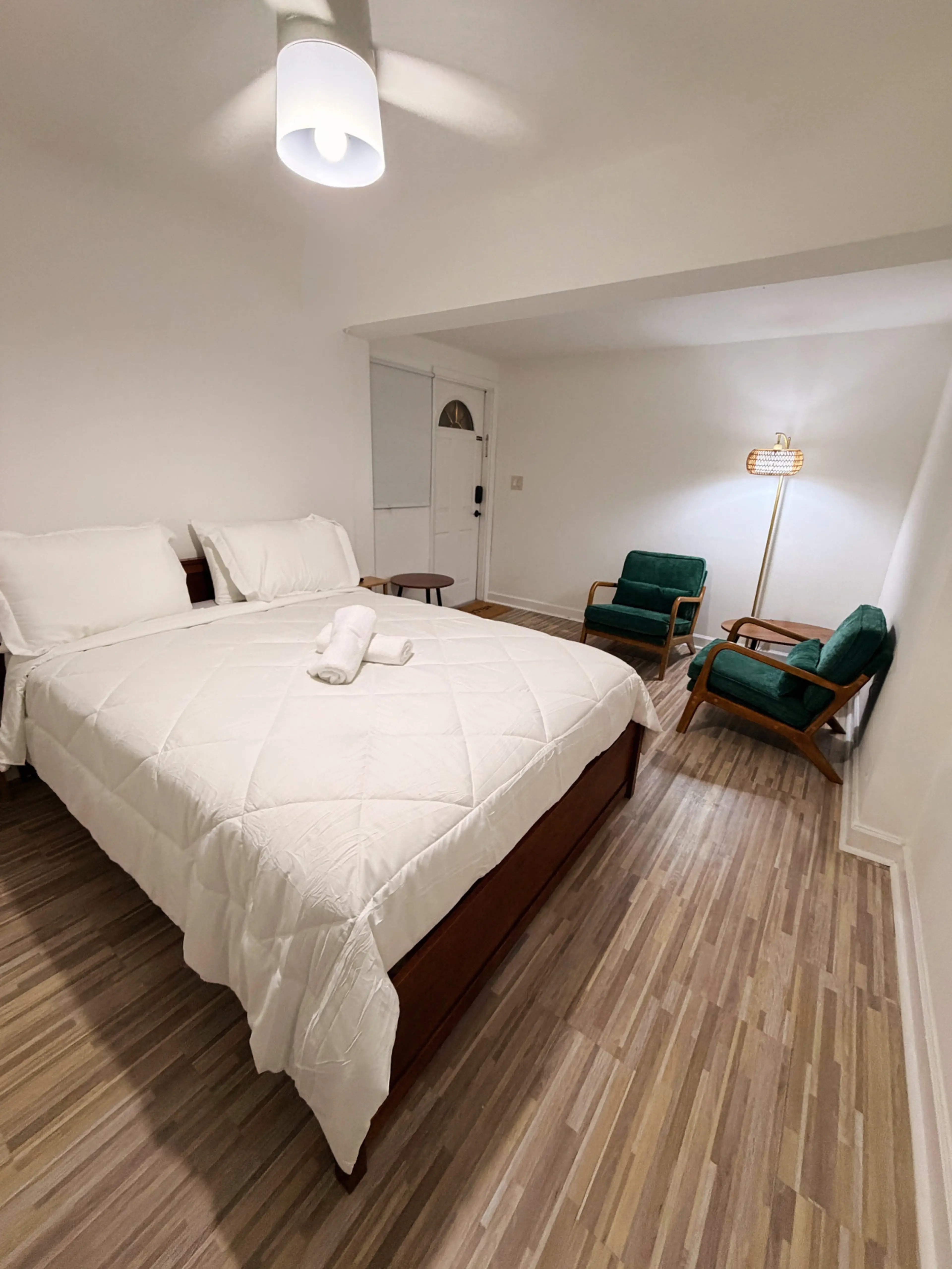 Spacious bedroom with a queen bed, cozy lounge area, and private entrance.