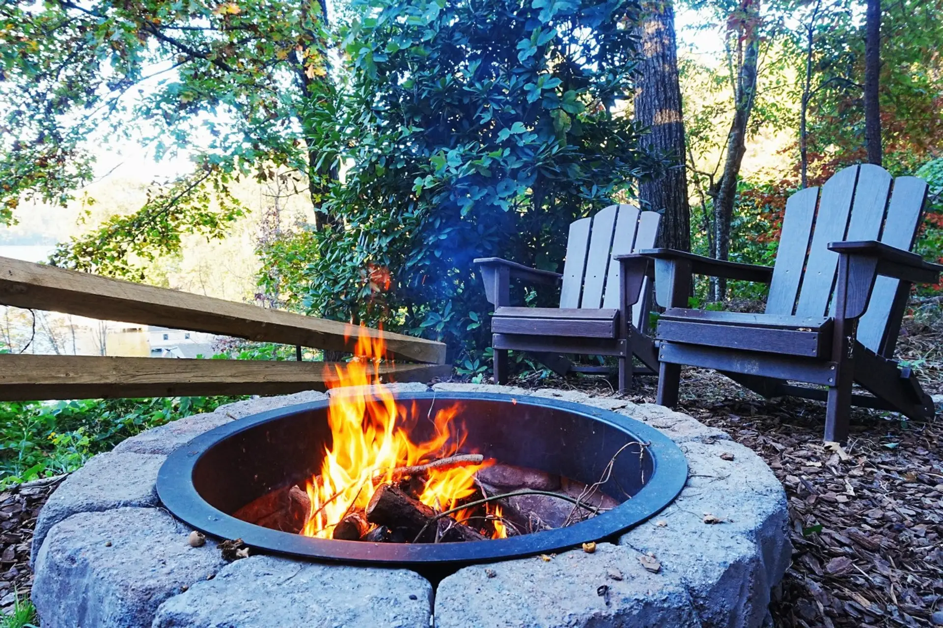 Stone fire pit with Adirondack chairs