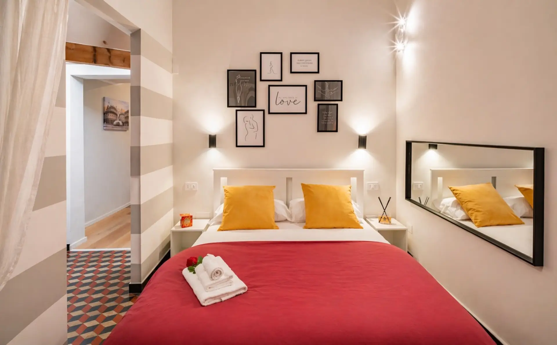 Camera da letto matrimoniale accogliente e curata, con illuminazione calda e arredi studiati per il relax. Un ambiente intimo e silenzioso, ideale per riposare e vivere il soggiorno con tranquillità nel centro storico di Genova.