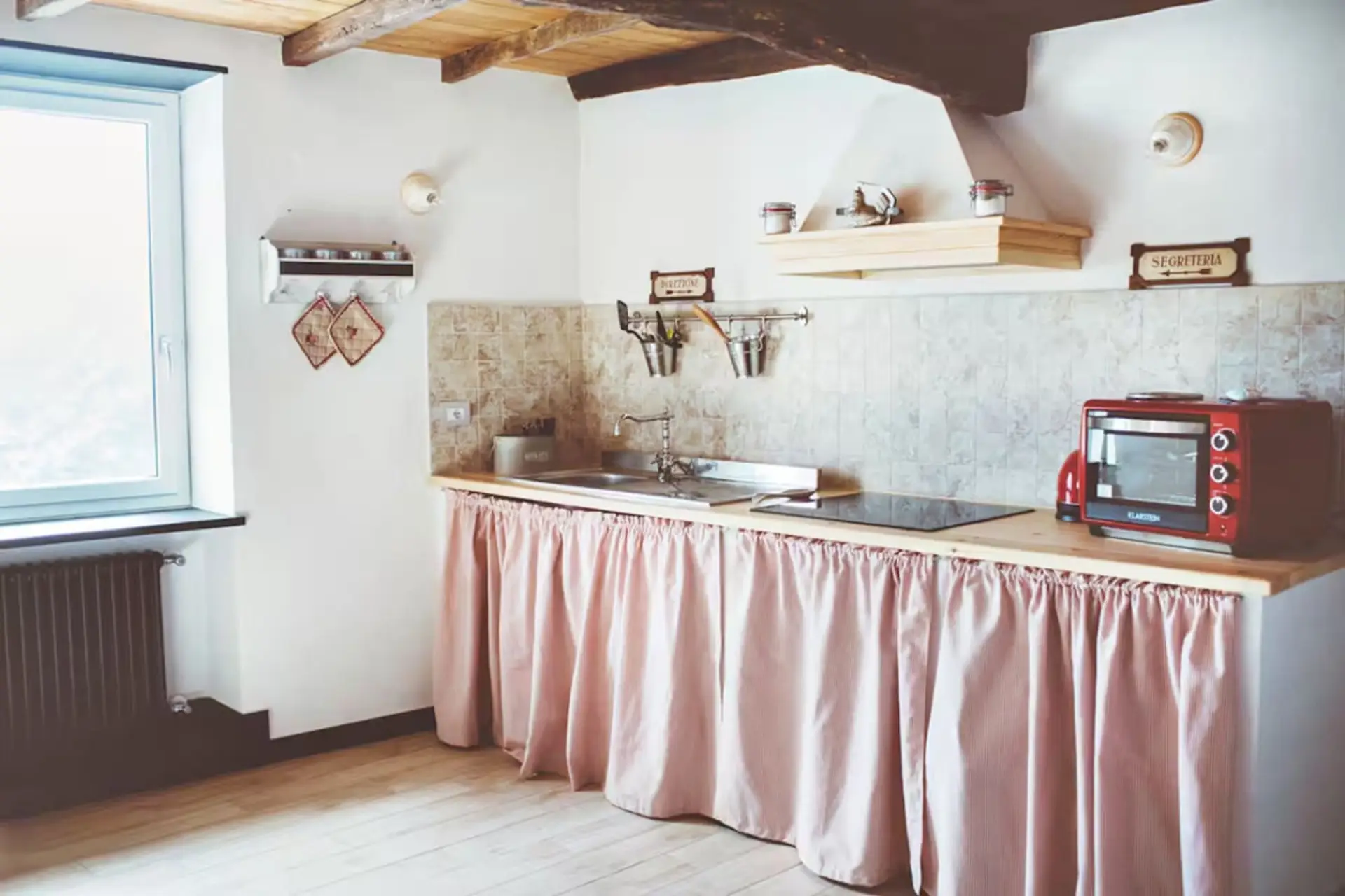 Cucina dal sapore ligure, con travi in legno e luce naturale che entra dalla finestra. Completa di piano induzione, frigorifero con congelatore, macchina del caffè e bollitore.Troverai piatti, posate, teglie e calici da vino e utensili da cucina vari