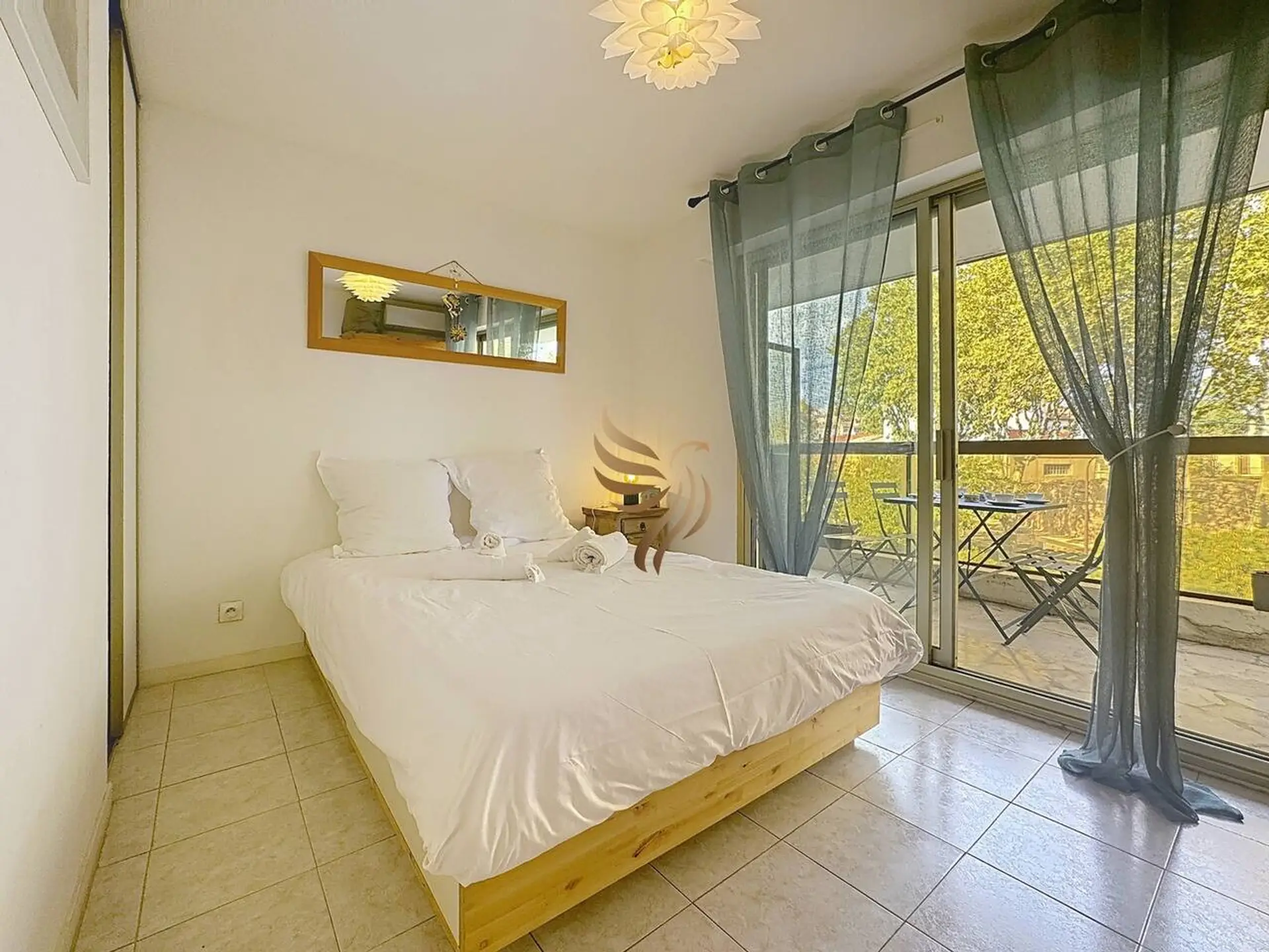 Chambre lumineuse avec lit double, grands rangements et accès au balcon.