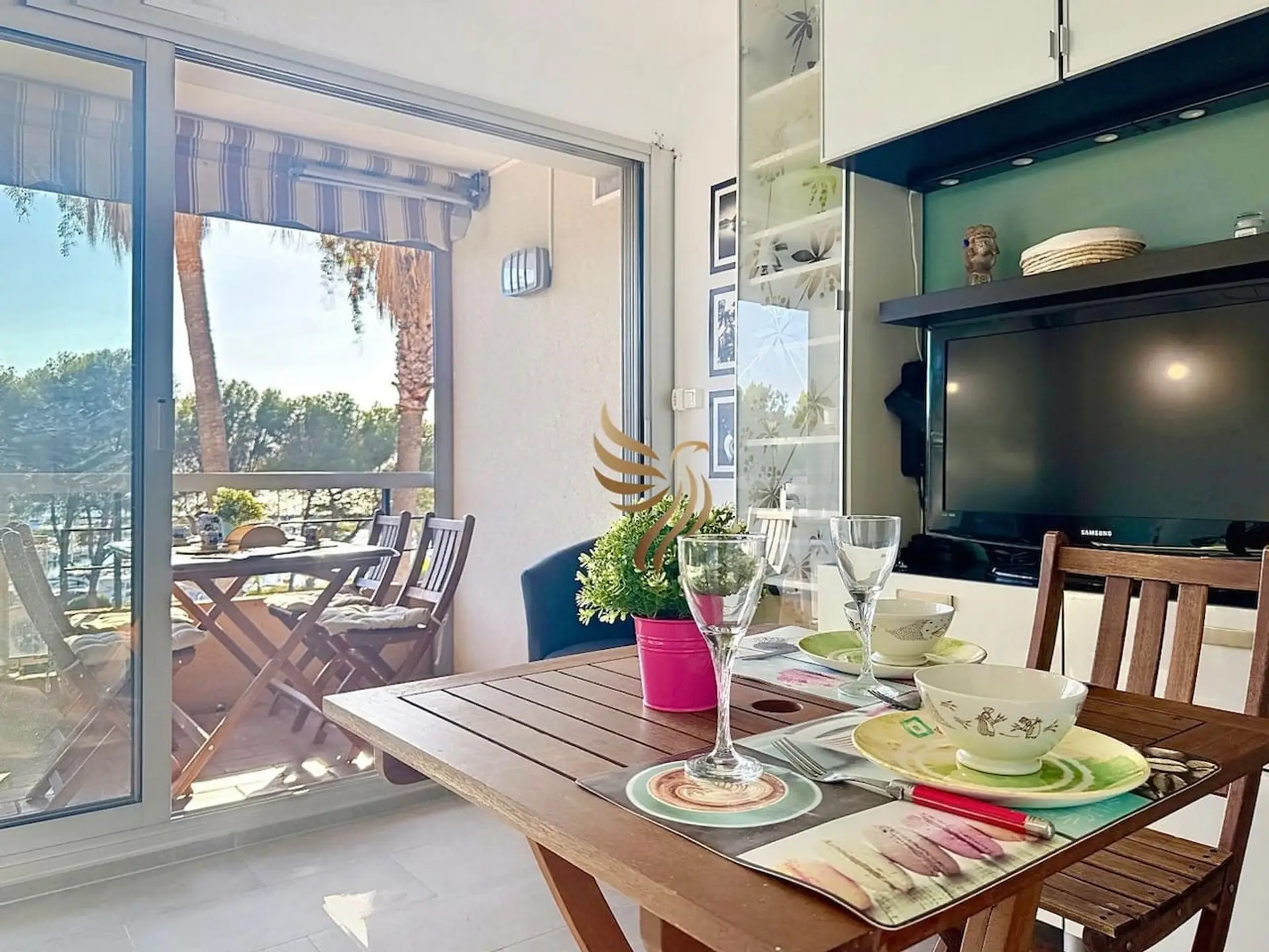 Ambiance chaleureuse avec une table dressée face à la terrasse, idéale pour des repas détendus.
