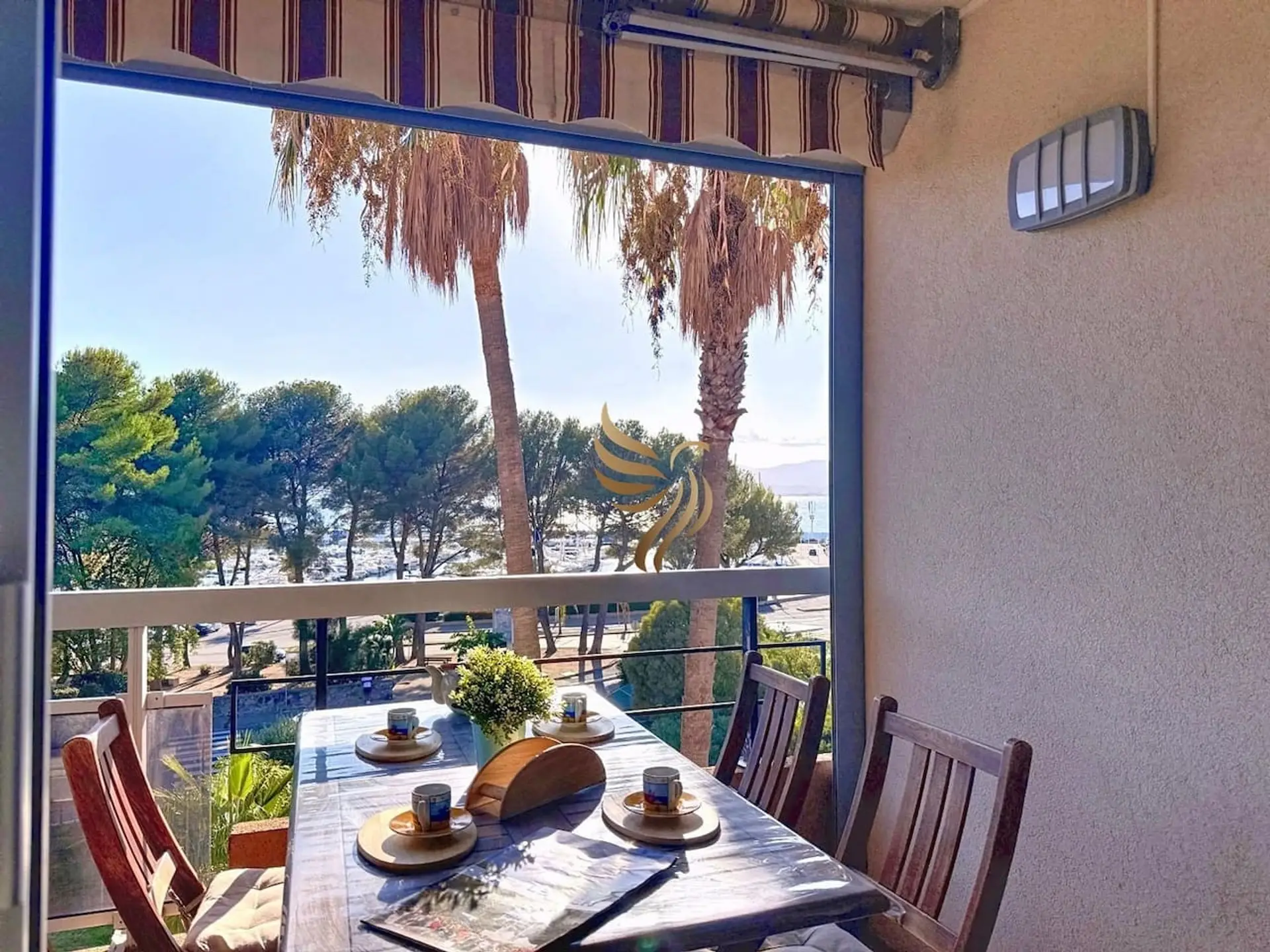 Table à manger extérieur, vue donnant sur les palmiers et la Marina.