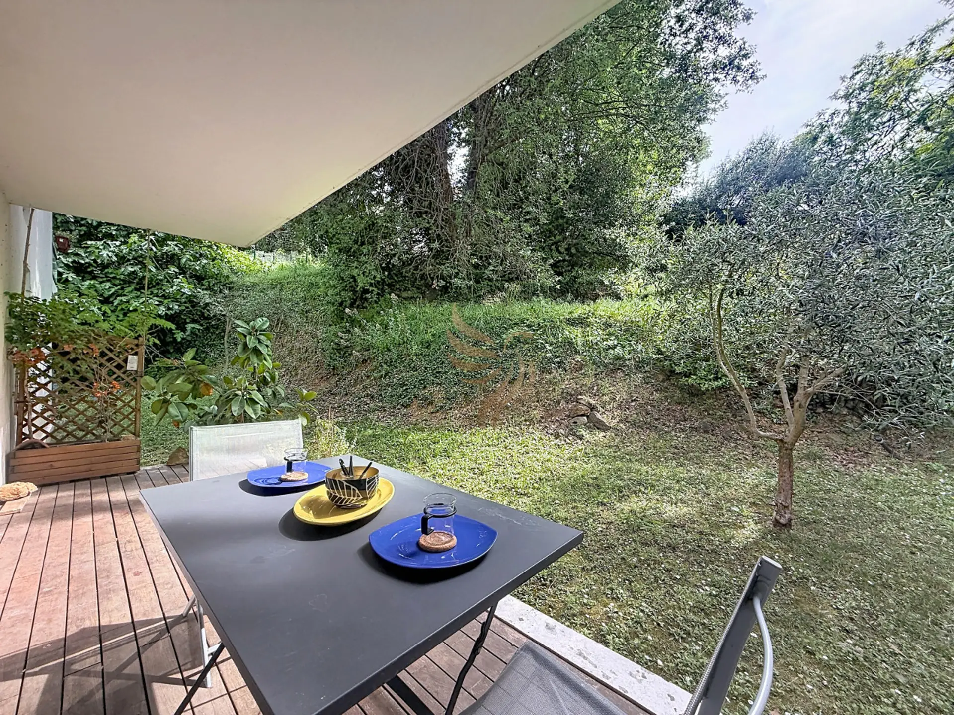 Installez-vous sous l'auvent : une table prête pour un petit-déjeuner coloré, le chant des oiseaux et la pelouse verdoyante comme unique voisin pour un moment paisible.