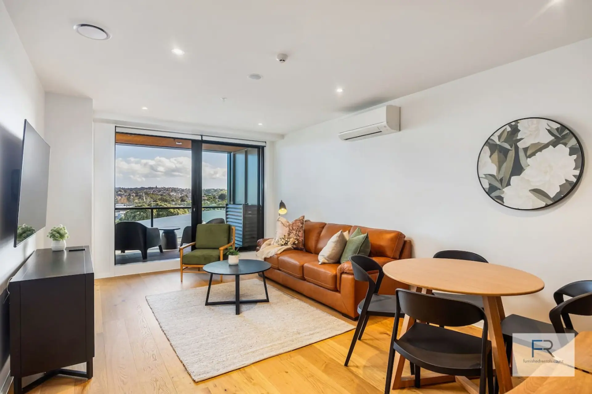 Stylish open plan living room with balcony opening out to harbour views